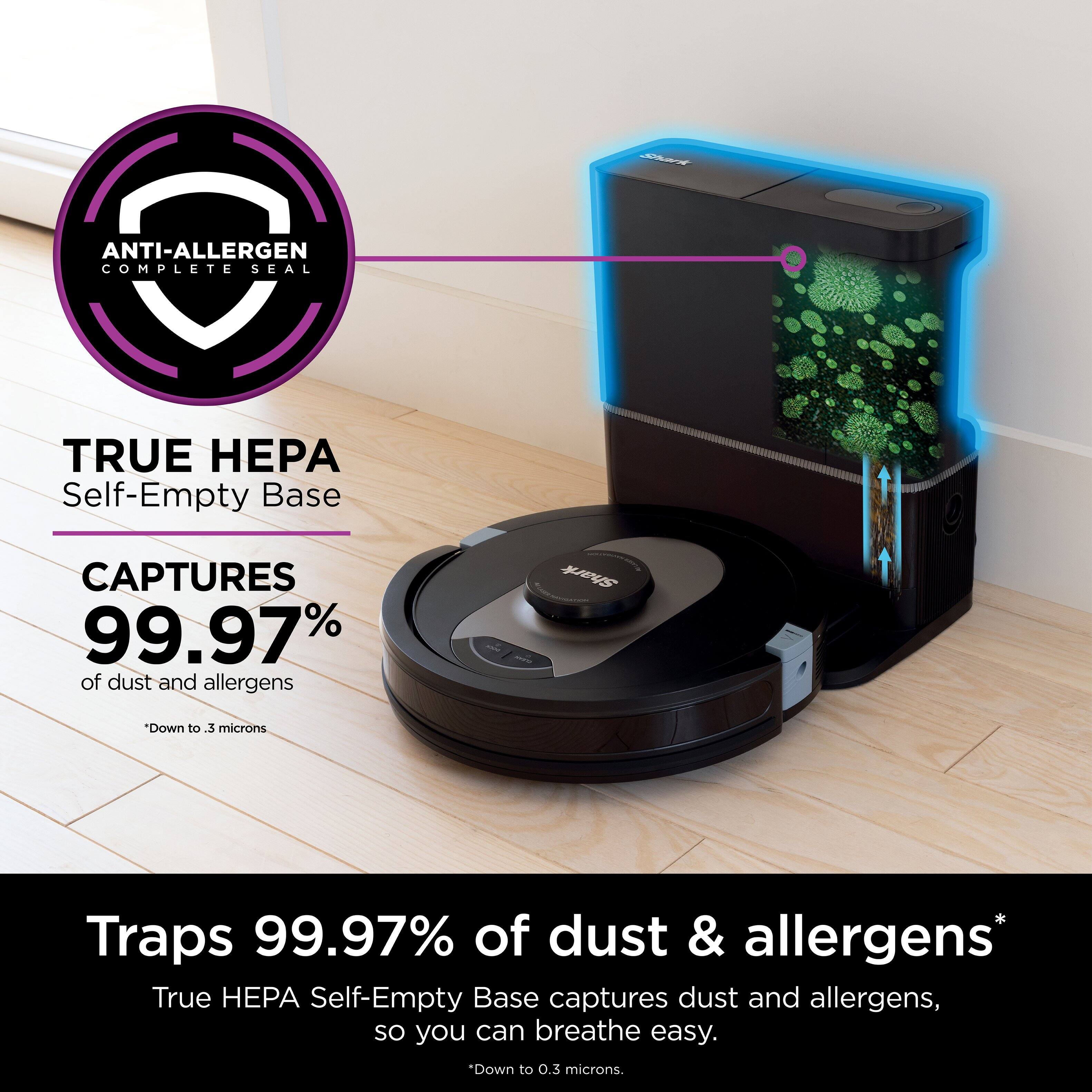 The image showcases a True HEPA self-empty base, which is designed to capture 99.97% of dust and allergens. The device is placed on a wooden floor, and it is surrounded by a few other objects. The main focus of the image is the True HEPA self-empty base, which is a vacuum cleaner that helps maintain a clean and allergen-free environment.