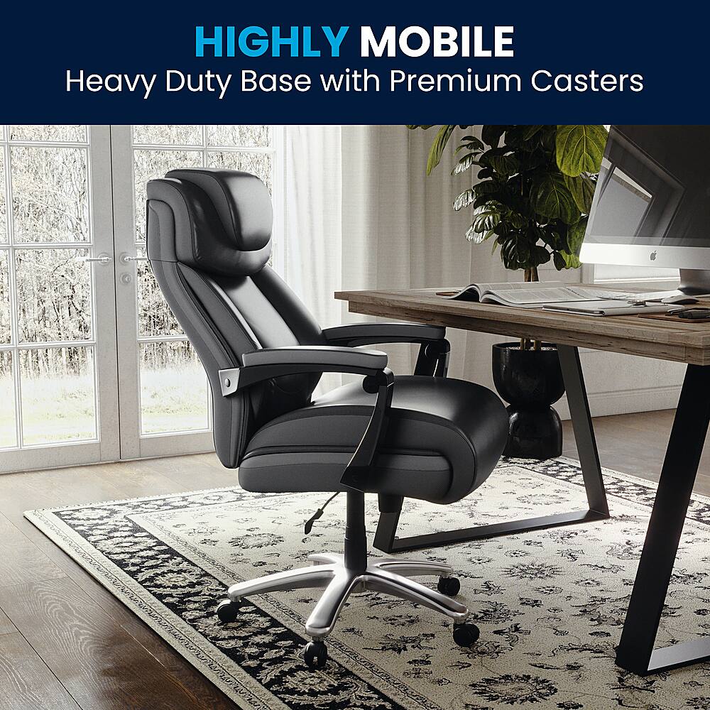 The image features a black office chair with a heavy duty base and premium casters. The chair is placed on a rug, and there is a desk with a computer and a potted plant nearby. The combination of the chair's design and the casters suggests that it is highly mobile, allowing for easy movement and adjustment within the workspace.