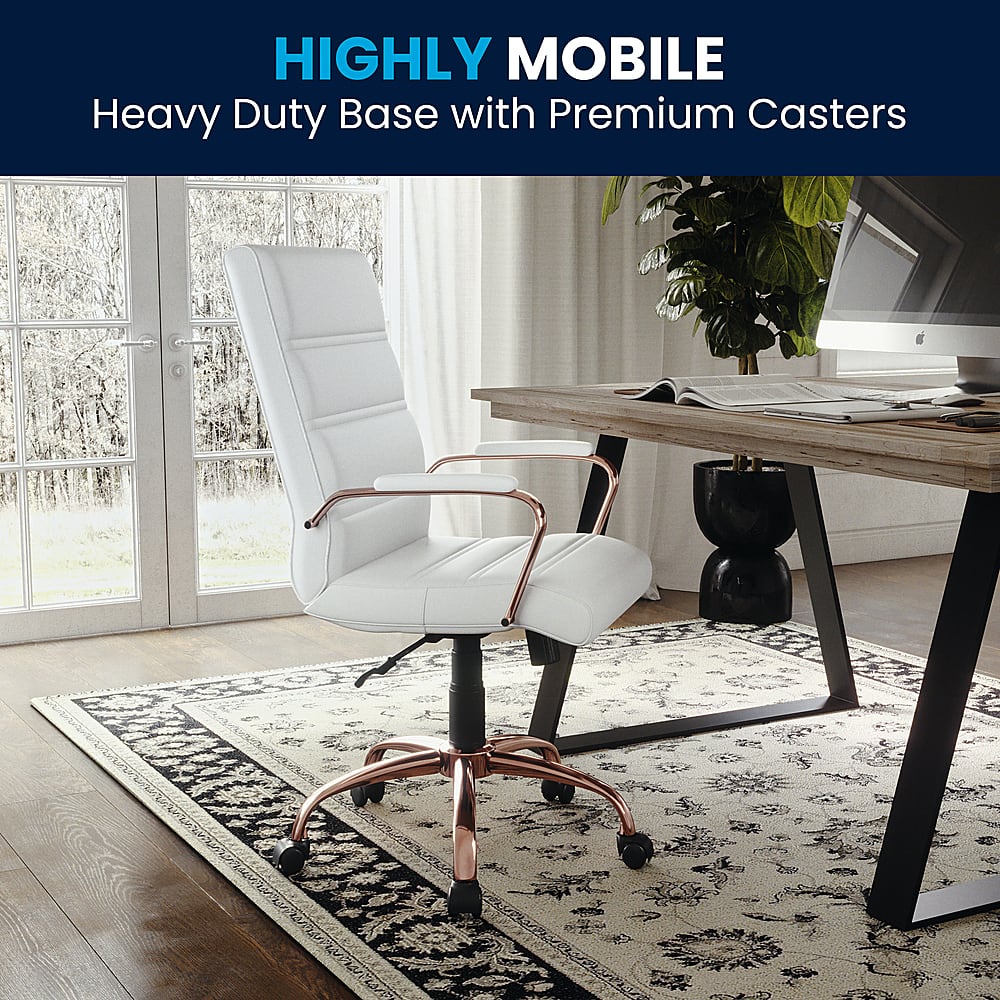 The image features a white office chair with a heavy duty base and premium casters. The chair is placed on a rug, and there is a desk nearby with a laptop and a keyboard on it. The scene also includes a potted plant and a TV, creating a comfortable and functional workspace.