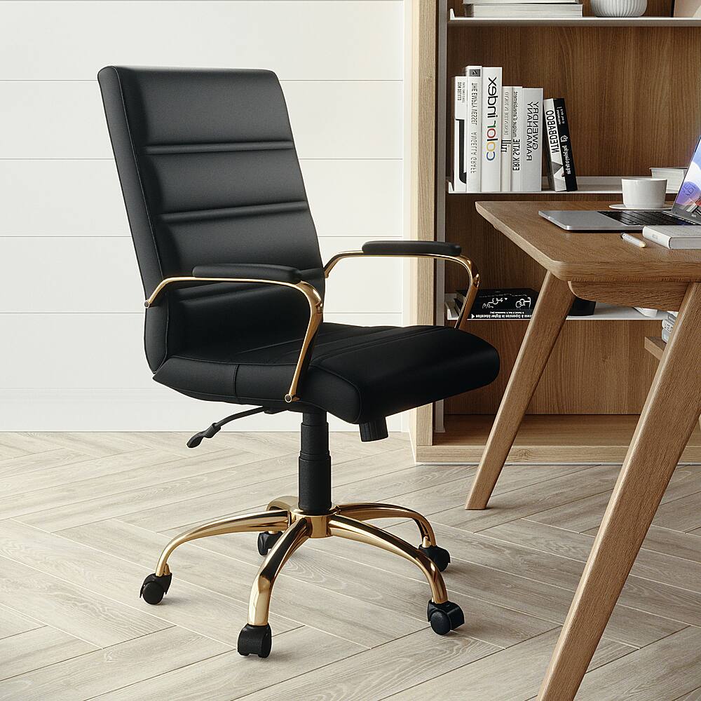 The image features a black office chair with gold trim, placed in front of a wooden desk. The desk has a laptop and several books on it, creating a workspace. There is also a cup on the desk. The chair is positioned next to a bookshelf, which contains more books. The scene is set on a hardwood floor, giving the space a warm and inviting atmosphere.