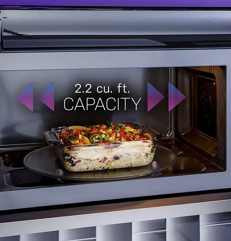 The image features a microwave with a casserole dish filled with food inside it. The microwave is described as having a 2.2 cubic foot capacity.