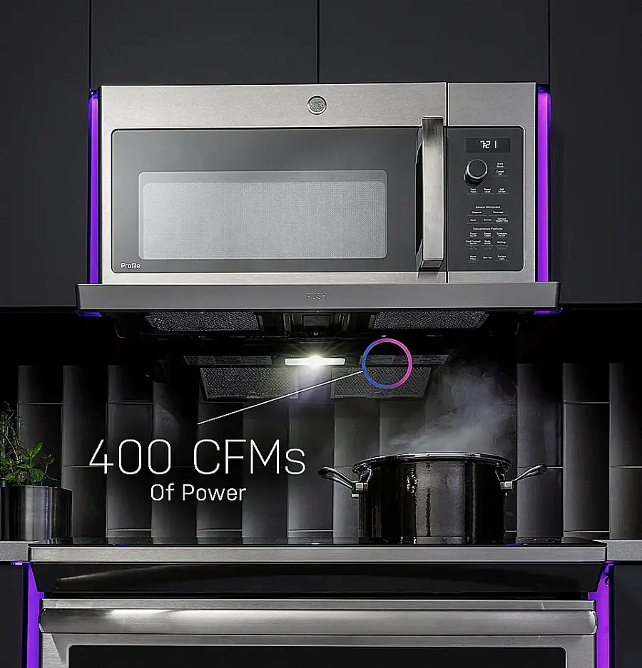 The image features a stainless steel microwave and oven combo, with a pot on the stove top. The microwave is placed above the oven, and the oven is described as having 400 CFMs of power. The image also includes a potted plant, adding a touch of greenery to the scene.