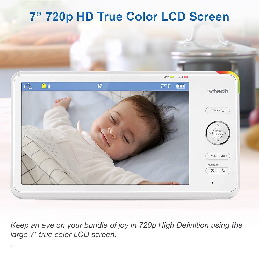 The image features a baby lying on a bed, with a Vtech monitor displaying the baby's image on a large 7" 720p HD true color LCD screen. The monitor is designed to keep an eye on your bundle of joy in 720p high definition, providing a clear and detailed view of the baby. The Vtech Talk 1 Monitor is a reliable and convenient tool for parents to monitor their child's well-being and ensure their safety while they are in the room.