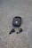 The text on the image is "adidas adidas," which is a repetition of the brand name. It is not a description of the image content. The image actually shows a pair of black Adidas earbuds sitting on a grey surface.
