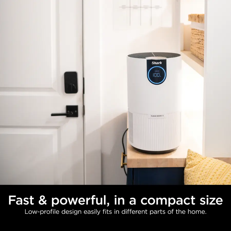 The image features a white appliance, possibly a Shark product, sitting in a kitchen. The appliance is compact and powerful, making it a convenient addition to the home. The design is low-profile, allowing it to easily fit in various parts of the house.