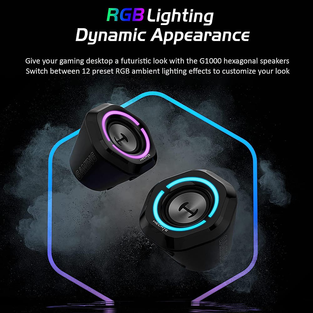 The image showcases a pair of black and purple computer speakers with RGB lighting. The speakers are designed to give a futuristic look to your gaming desktop. With the G1000 hexagonal speakers, you can switch between 12 preset RGB ambient lighting effects to customize your look. The speakers are equipped with a switch that allows you to change between different lighting effects, providing a dynamic appearance that enhances your gaming experience.