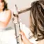 The image features a woman using a hair curler, which is an automatic hair curler with Coanda Technology. The curler is designed to wrap, curl, and set the hair automatically, making it a convenient and efficient tool for styling. The woman is holding the curler close to her hair, and it is wrapping and curling the hair as it sets.