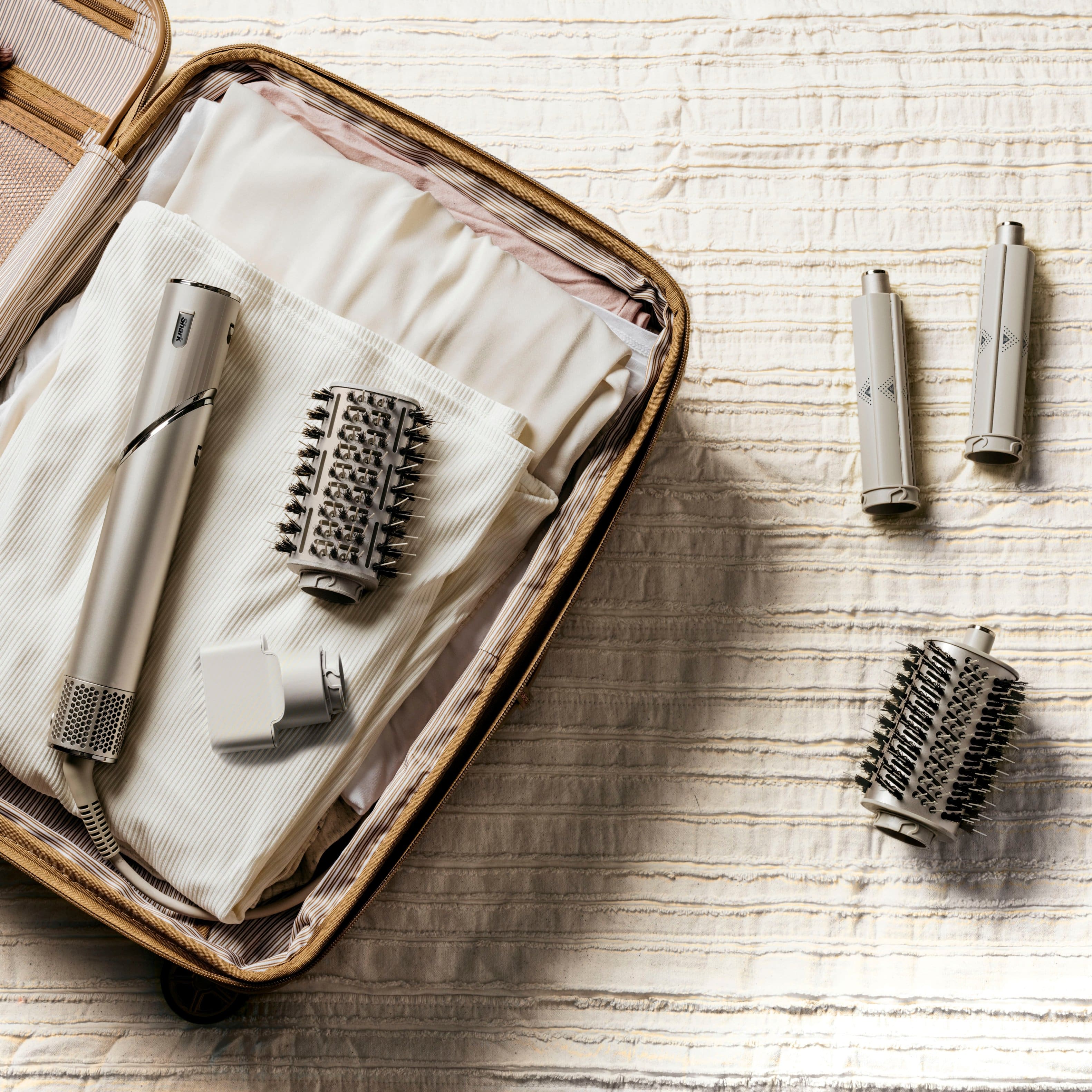 The image features a suitcase filled with various items, including a hair dryer, a toothbrush, and a pair of scissors. The suitcase is open, revealing the contents inside. The hair dryer is placed on top of the suitcase, while the toothbrush and scissors are located nearby. The suitcase is filled with personal items, making it a convenient and organized traveling companion.