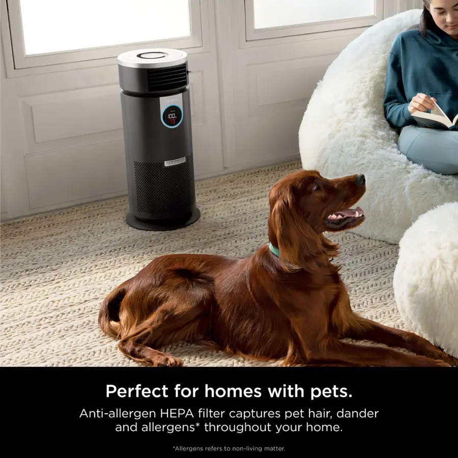The image features a dog lying on the floor next to a person who is sitting on a chair. The person is reading a book, and there is a small heater nearby. The scene appears to be a cozy and comfortable living space. The text "Perfect for homes with pets" suggests that the environment is suitable for pet owners, as it provides a comfortable and safe space for both the person and the dog. The presence of an anti-allergen HEPA filter indicates that the home is designed to minimize allergens and pet hair, making it a more pleasant environment for those with allergies or sensitivities.