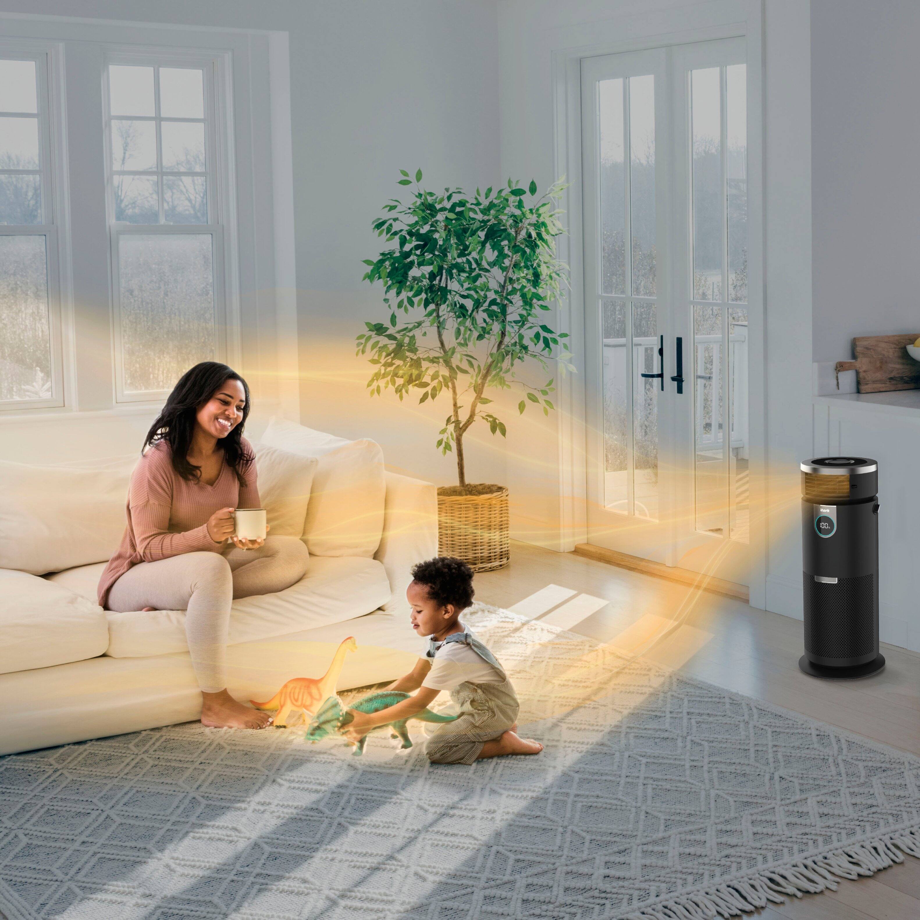 The image features a purified air machine placed on a wooden floor next to a couch. The air purifier is designed to provide fast, quiet, and powerful purification, making it an ideal choice for improving indoor air quality. The machine is positioned in the center of the image, with the couch occupying the right side of the frame. The overall scene suggests a comfortable and clean living space.