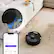The image shows a robotic vacuum cleaner on a carpeted floor, with a cell phone displaying the robot's status. The robotic vacuum is designed to clean your home, including the playroom, and it can take around 100% of the time to clean your kitchen. The vacuum is equipped with different power levels, including Eco, Normal, and Max, to suit various cleaning needs. The cell phone app allows you to monitor and control the robotic vacuum from your phone, making it a convenient and efficient cleaning solution.