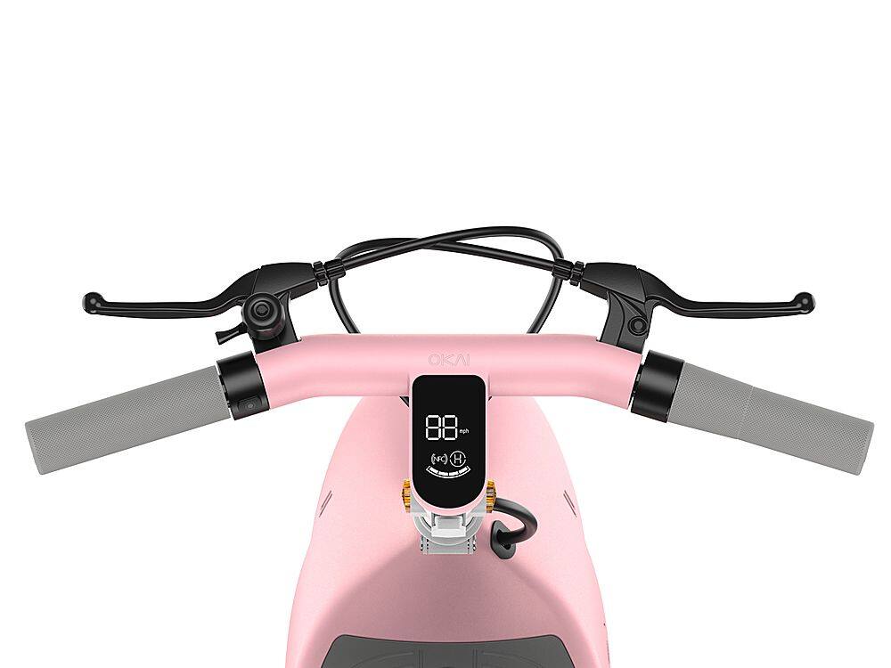 The image features a pink scooter with a black handlebar and a black seat. The scooter has a digital display on the handlebar, which shows the time and possibly other information. The scooter is parked in a white background, making it stand out. The handlebar is equipped with a speedometer and a clock, providing the rider with essential information while riding.
