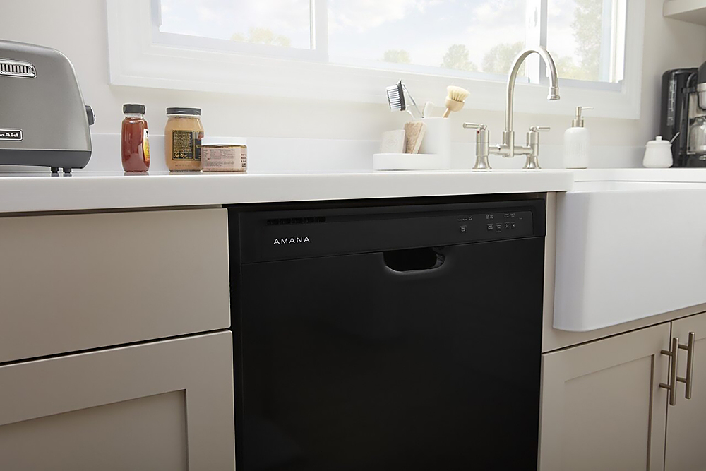 Built-in dishwashers are a popular choice for many homeowners due to their space-saving design and convenience. In the image, there is a black Amana dishwasher installed under a white sink, which is a common setup in many kitchens. The dishwasher is located in a kitchen cabinet, which helps to keep the appliance out of sight when not in use. This type of installation not only saves space but also provides a clean and organized look in the kitchen.