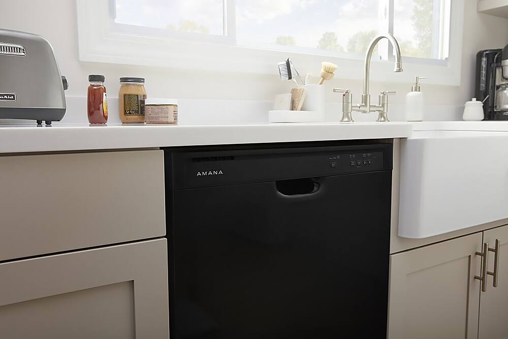 Built-in dishwashers are a popular choice for many homeowners due to their space-saving design and convenience. In the image, there is a black Amana dishwasher installed under a white sink, which is a common setup in many kitchens. The dishwasher is located in a kitchen cabinet, which helps to keep the appliance out of sight when not in use. This type of installation not only saves space but also provides a clean and organized look in the kitchen.