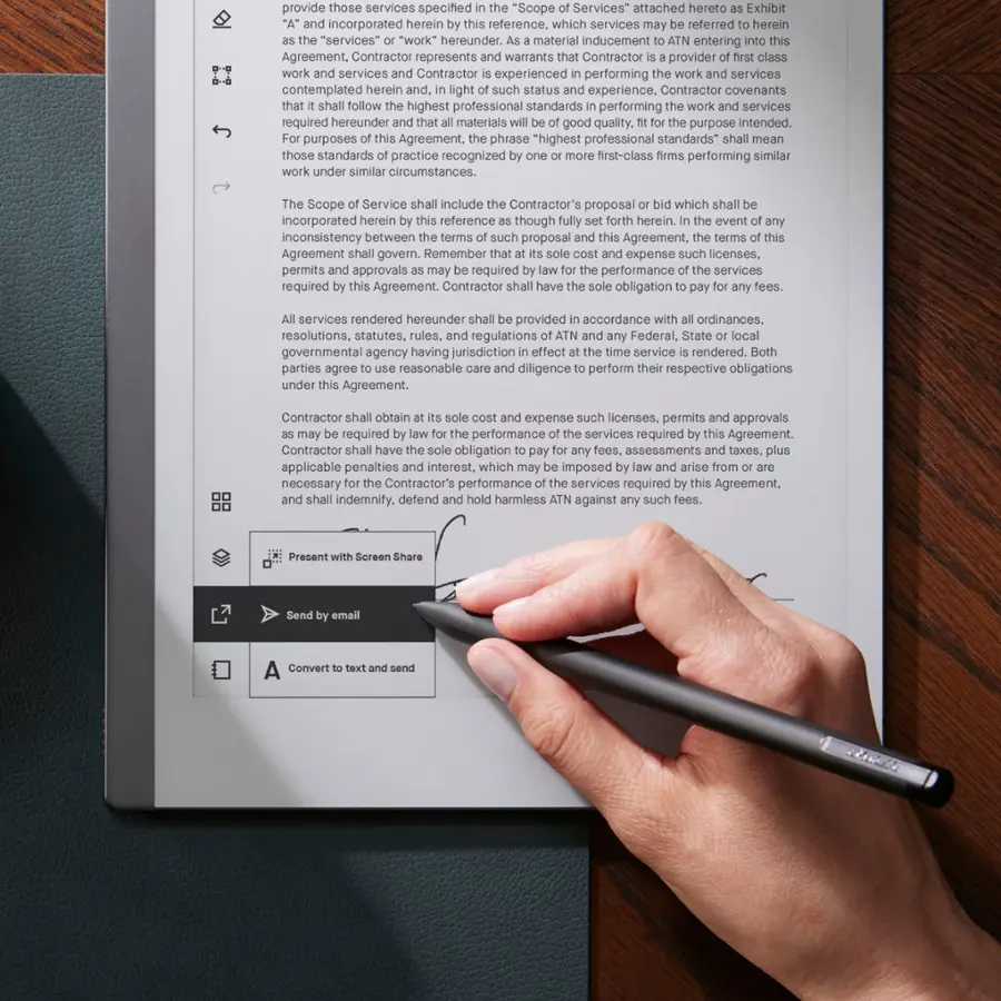 The text on the image is a legal document, which is being edited by a person using a pen. The document is related to providing services, and it contains several clauses and terms. The person is marking the document with a pen, possibly to highlight or correct specific parts of the text. The document is written in a formal and legal language, which is typical for contracts and agreements.