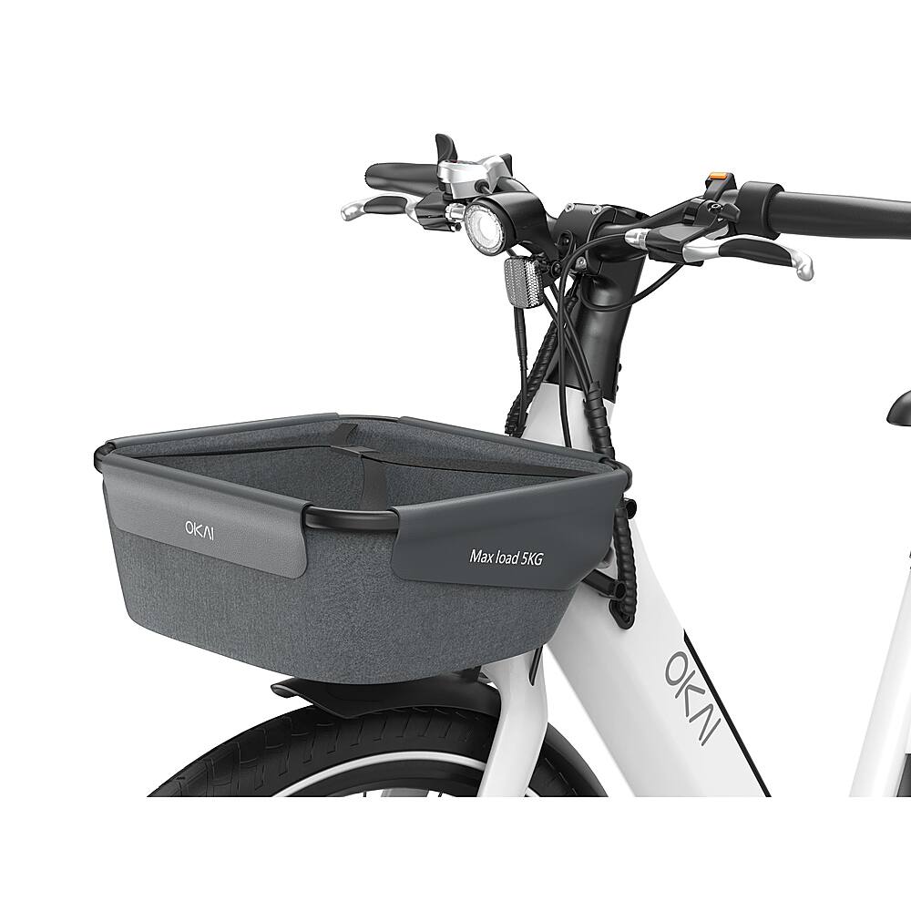 The image features a bicycle with a basket attached to the front. The basket is designed to carry a maximum load of 5 kilograms. The bicycle is white, and the basket is positioned in front of the handlebars. The scene is set against a white background, which highlights the bicycle and its accessory.