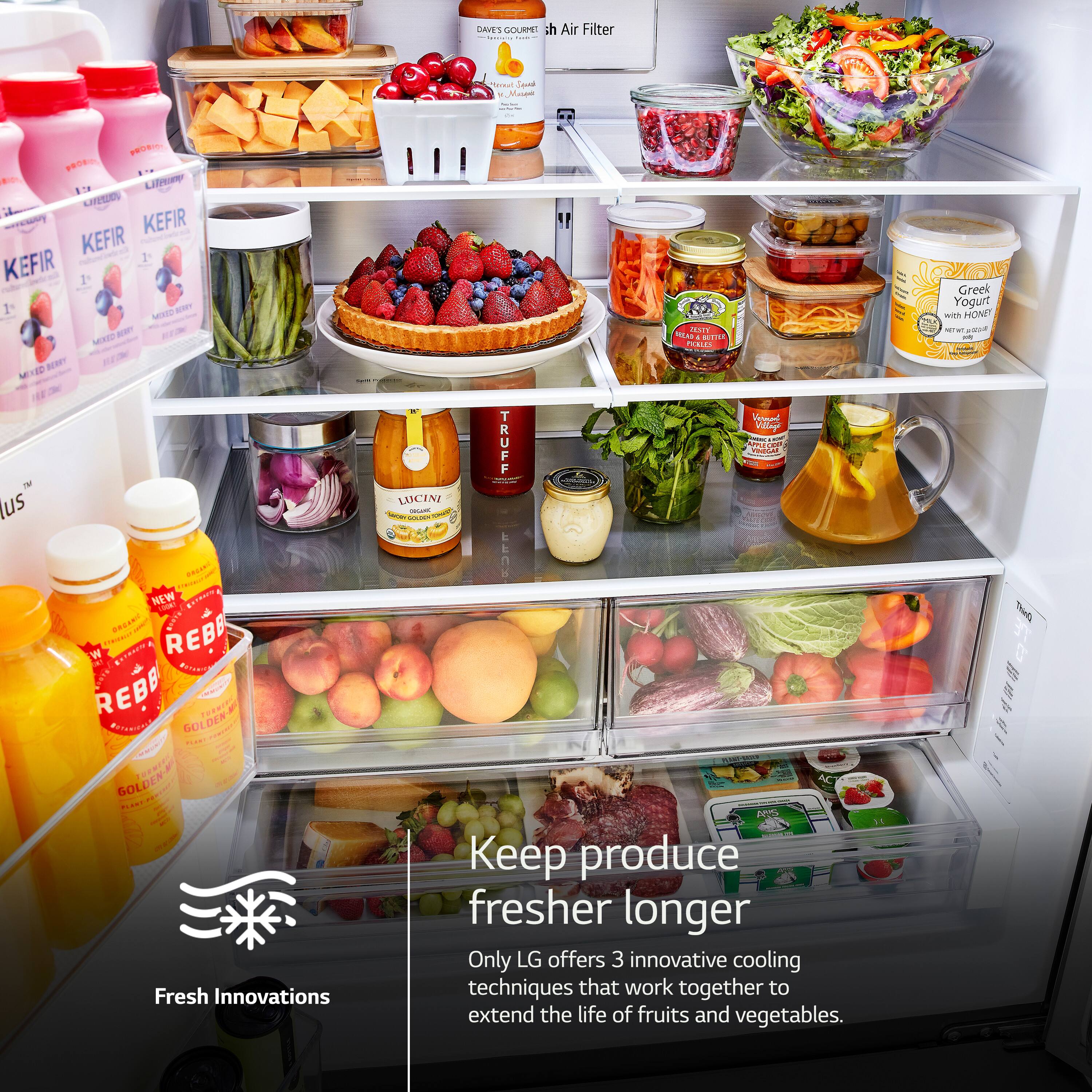 The image showcases a refrigerator filled with various food items, including fruits and vegetables. The refrigerator is stocked with a variety of items, such as apples, oranges, and broccoli. There are also several bottles of different sizes and shapes placed throughout the refrigerator. The refrigerator is well-organized, making it easy to find and access the desired items. The image promotes the idea of keeping produce fresher longer, emphasizing the importance of proper storage and organization of food items.