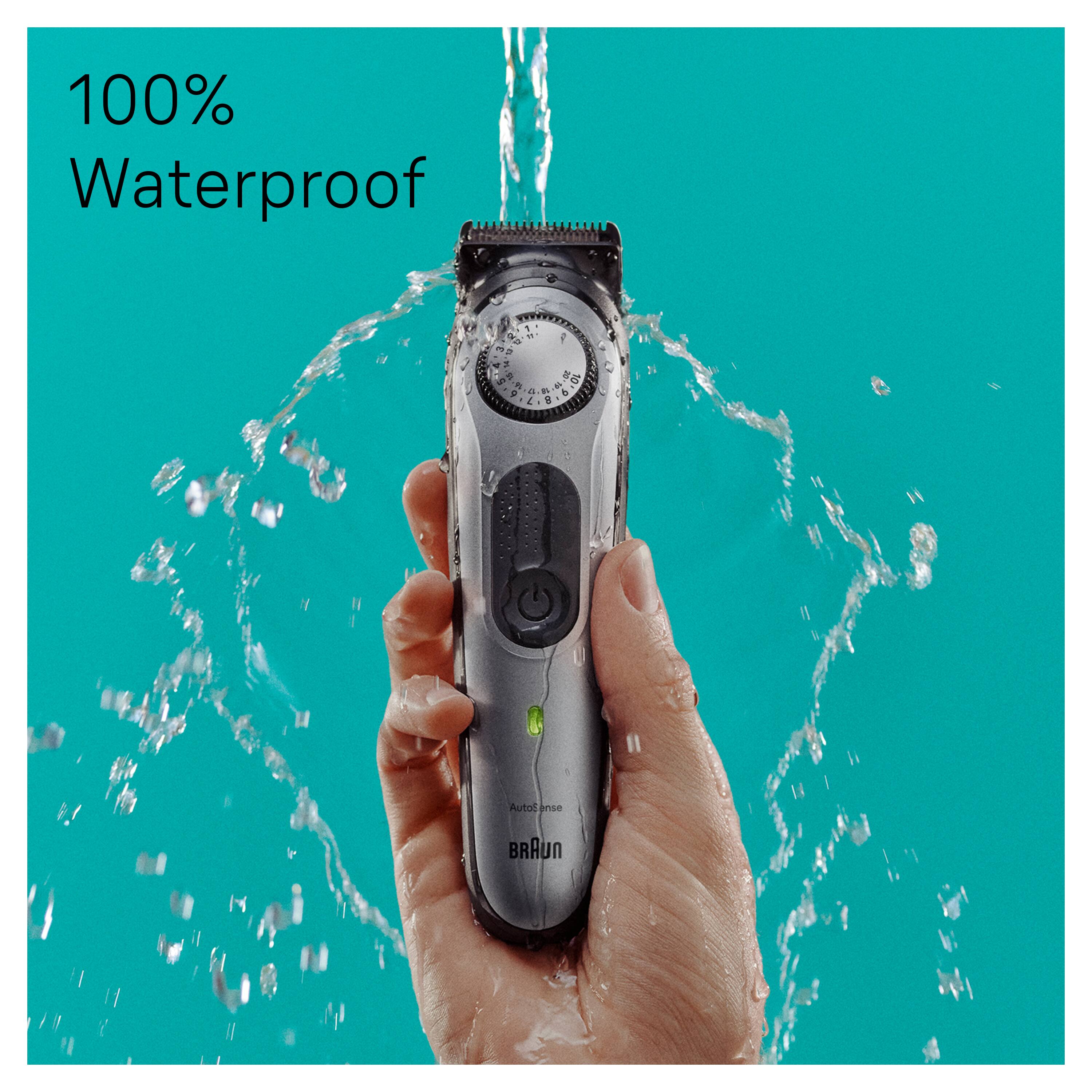 The image features a Braun waterproof hair trimmer, which is being used by a person to trim their hair. The hair trimmer is designed to be 100% waterproof, making it suitable for use in wet conditions. The person is holding the hair trimmer over a sink, which is filled with water, and the water is splashing around the trimmer. This suggests that the hair trimmer is being used in a wet environment, such as a bathroom, where water is commonly present.