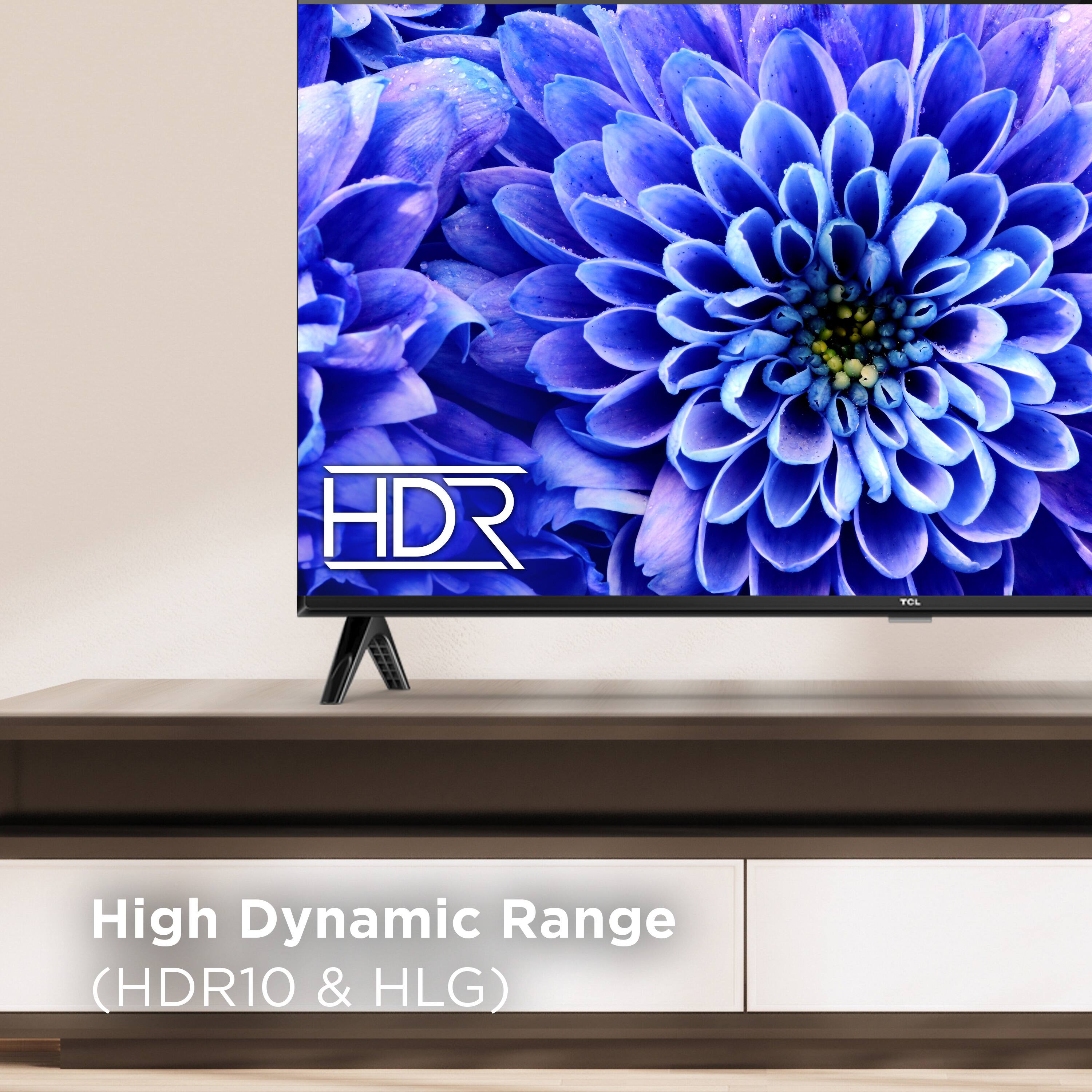 The image features a flat screen TV with a blue flower displayed on it. The TV is placed on a stand, and the flower is prominently displayed on the screen. The TV is advertised as having high dynamic range capabilities, which enhances the overall viewing experience. The image showcases the vibrant colors and details of the flower, highlighting the TV's ability to display high-quality visuals.