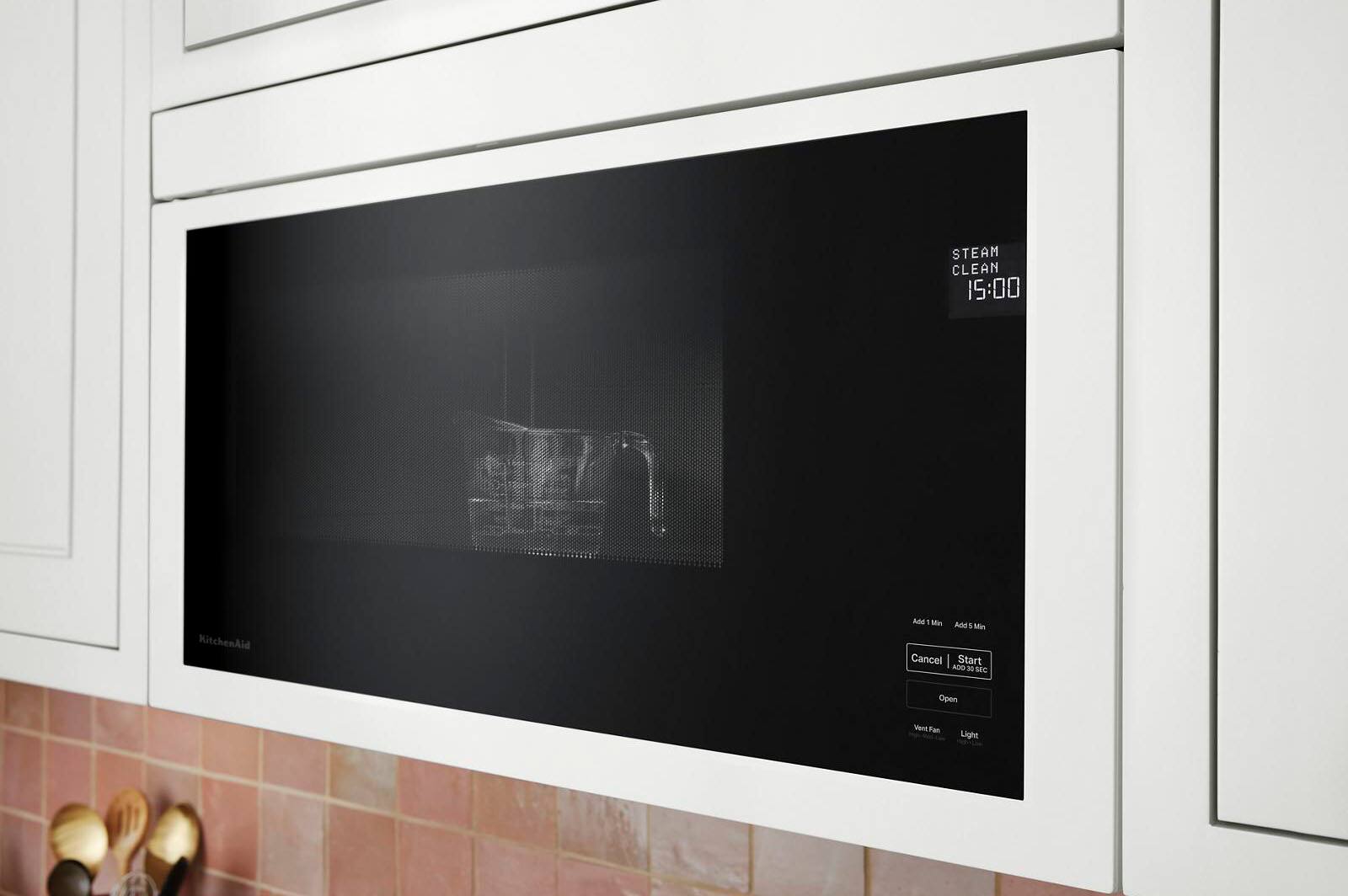 The image features a microwave oven with a black door and a black interior. The microwave is empty, with no food or items inside. It is a modern and sleek appliance, suitable for various cooking and heating tasks.