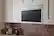 The image shows a modern, stainless steel microwave oven with a black screen. The microwave is placed on a white background, making it stand out. The oven is designed to be built into a wall, and it has a sleek, contemporary appearance.