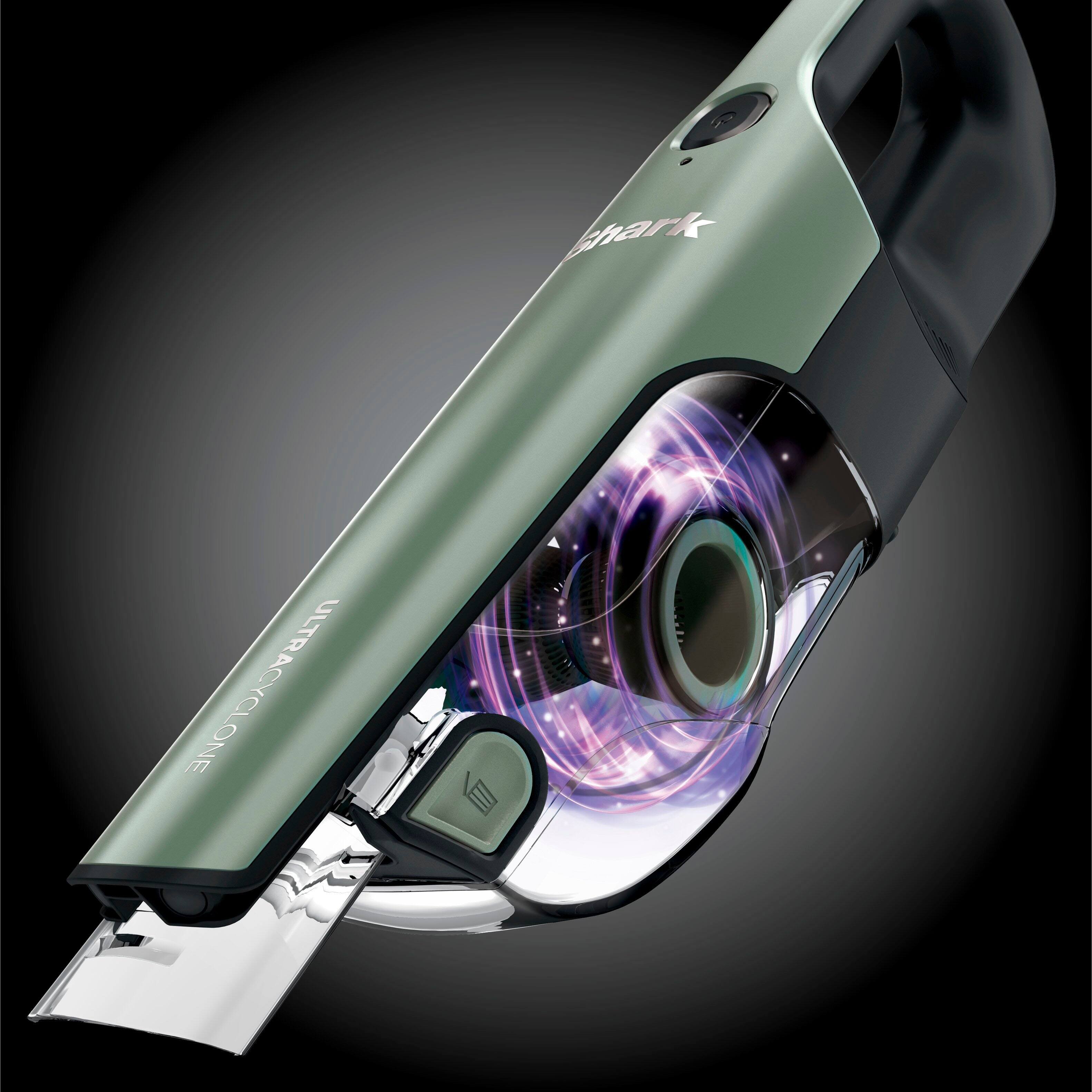 The image features a handheld vacuum cleaner with a green body and a purple light. The vacuum has a large, circular light on the front, which illuminates the area being cleaned. The vacuum is designed to be compact and easy to use, making it a convenient tool for cleaning various surfaces.