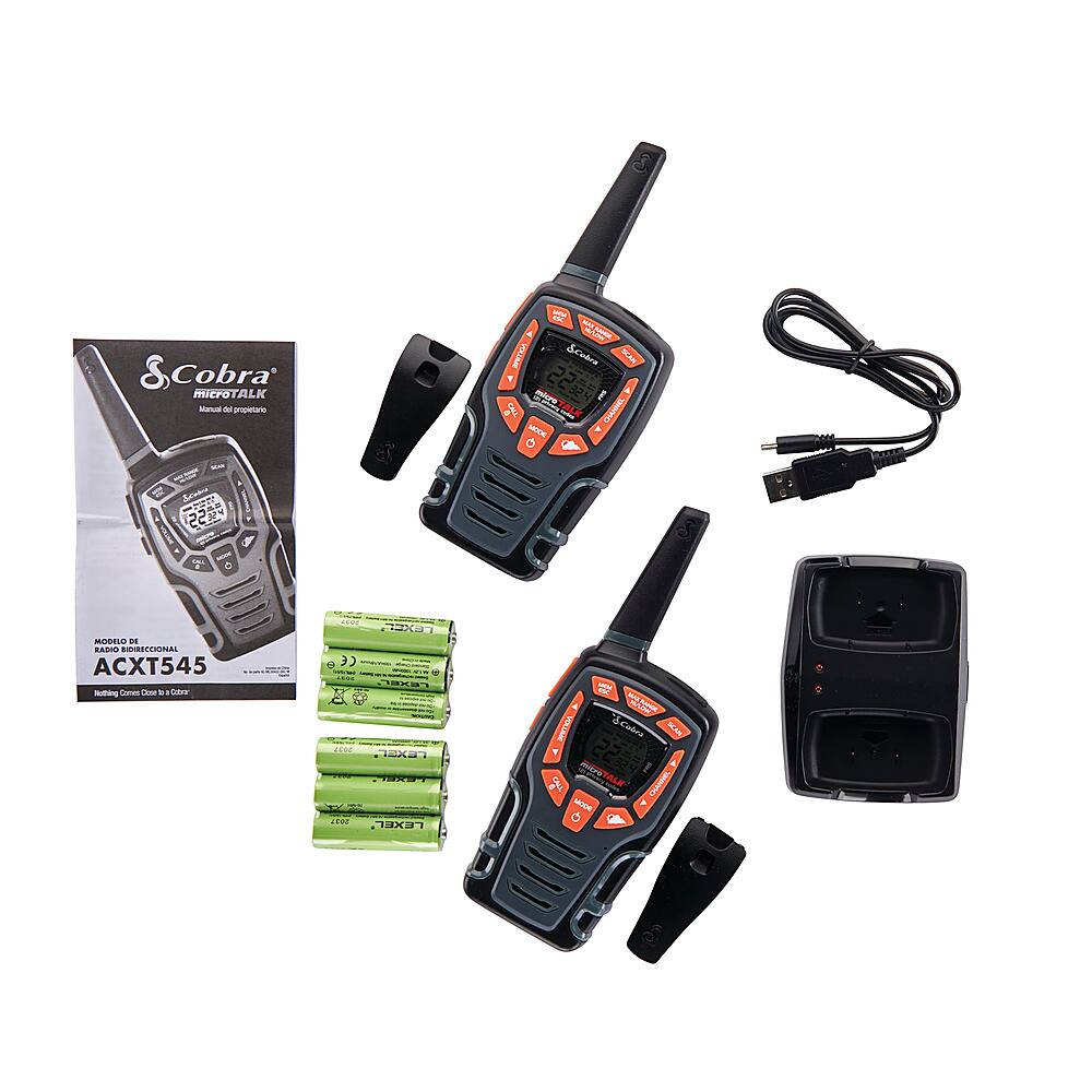 The image features a set of two Cobra walkie talkies, along with their accessories. The walkie talkies are placed on a white background, and they are accompanied by a charger, batteries, and a manual. The accessories include a black antenna and a black microphone. The scene showcases the various components that come with the walkie talkies, making it a complete and functional set for communication purposes.