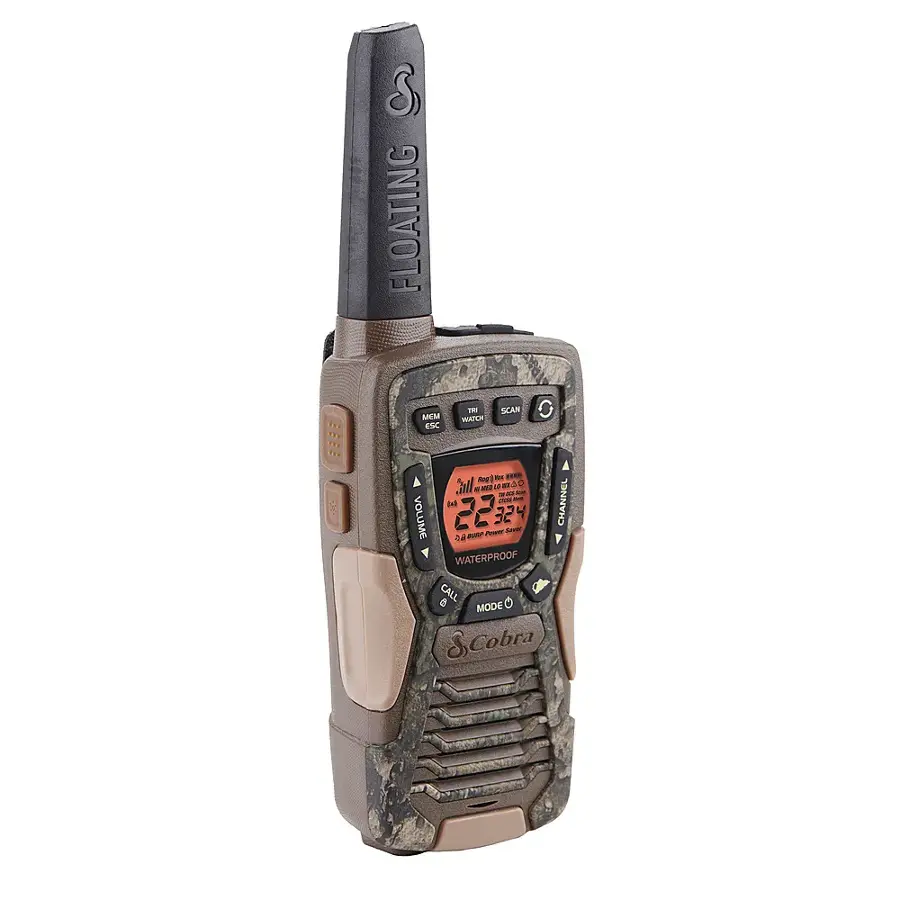 The image features a floating radio, which is waterproof and has a camouflage design. It is a two-way radio with a built-in speaker and microphone, and it is equipped with a flashlight. The radio is designed to be used in various weather conditions and is suitable for outdoor activities. The radio has a channel and volume control, and it can be used for both marine and land communication. The radio is made by the brand Cobra.
