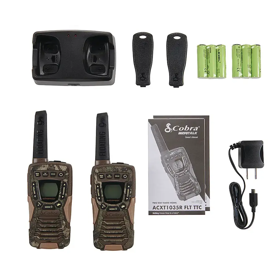 The image features a two-way radio, specifically a Cobra ACXT1035R FLT TTC, which is a floating radio. The radio is accompanied by a charger, a manual, and a set of batteries. There are also two remote controls and a set of batteries for the radio. The radio is designed to be waterproof and can be used in various outdoor activities.