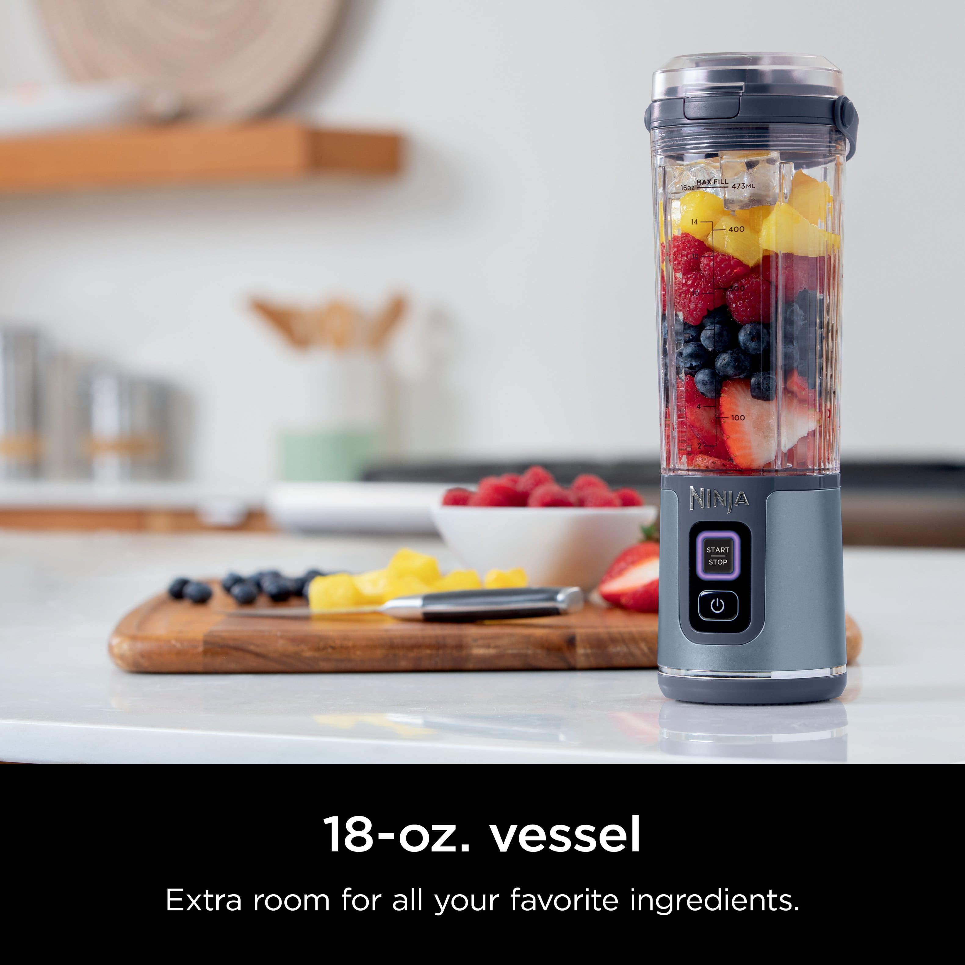 The image features a Ninja blender filled with various fruits, including strawberries, blueberries, and raspberries. The blender is placed on a countertop, surrounded by other kitchen items such as a bowl and a knife. The image promotes the Ninja blender as a convenient and versatile appliance, perfect for blending and mixing various ingredients.