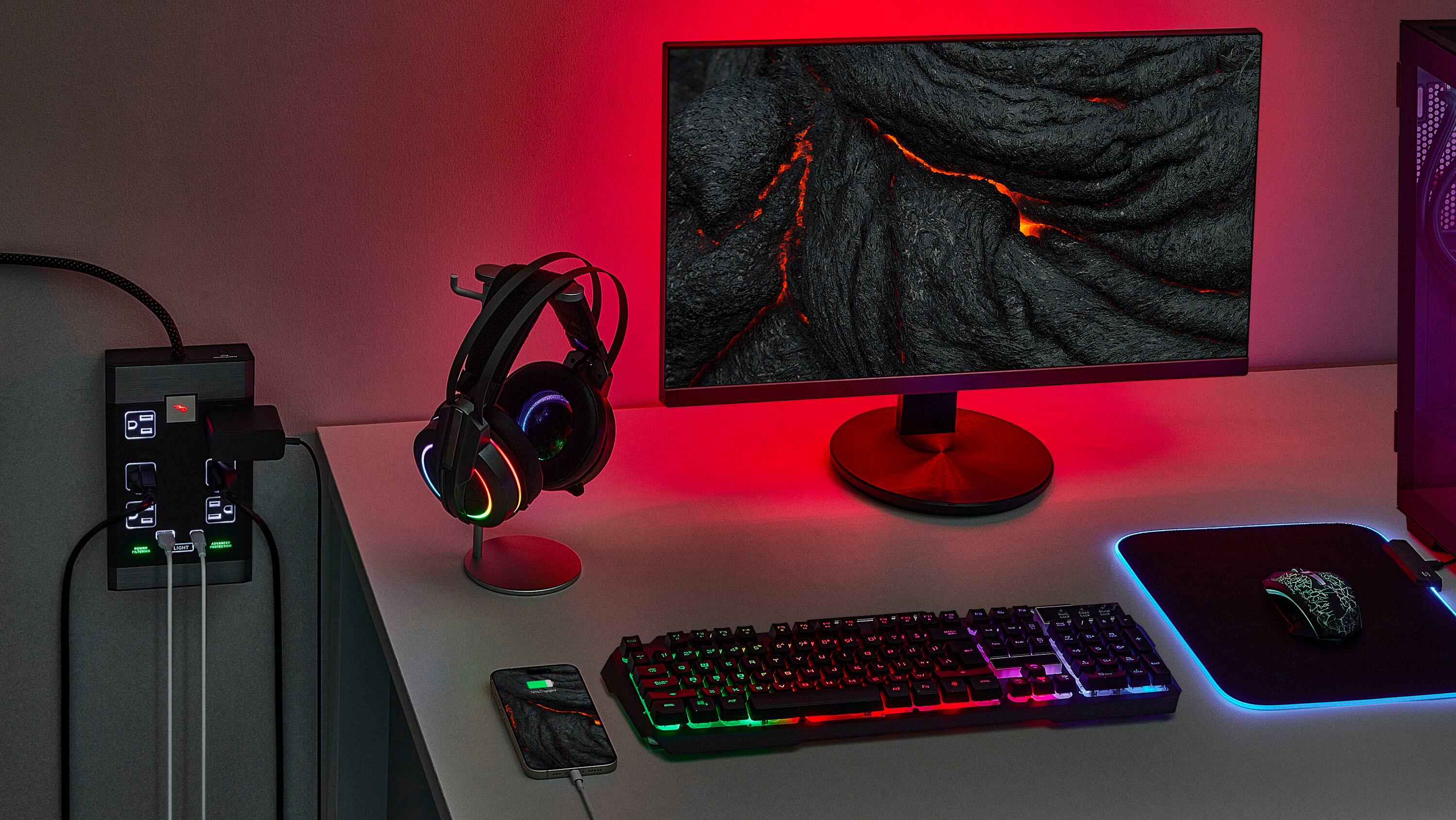 The image features a computer setup with a keyboard, mouse, and monitor. The keyboard has a green and purple color scheme, and the monitor is displaying a red screen. There is also a cell phone placed next to the keyboard. The computer setup is placed on a desk, which is situated in a room with a red glow.
