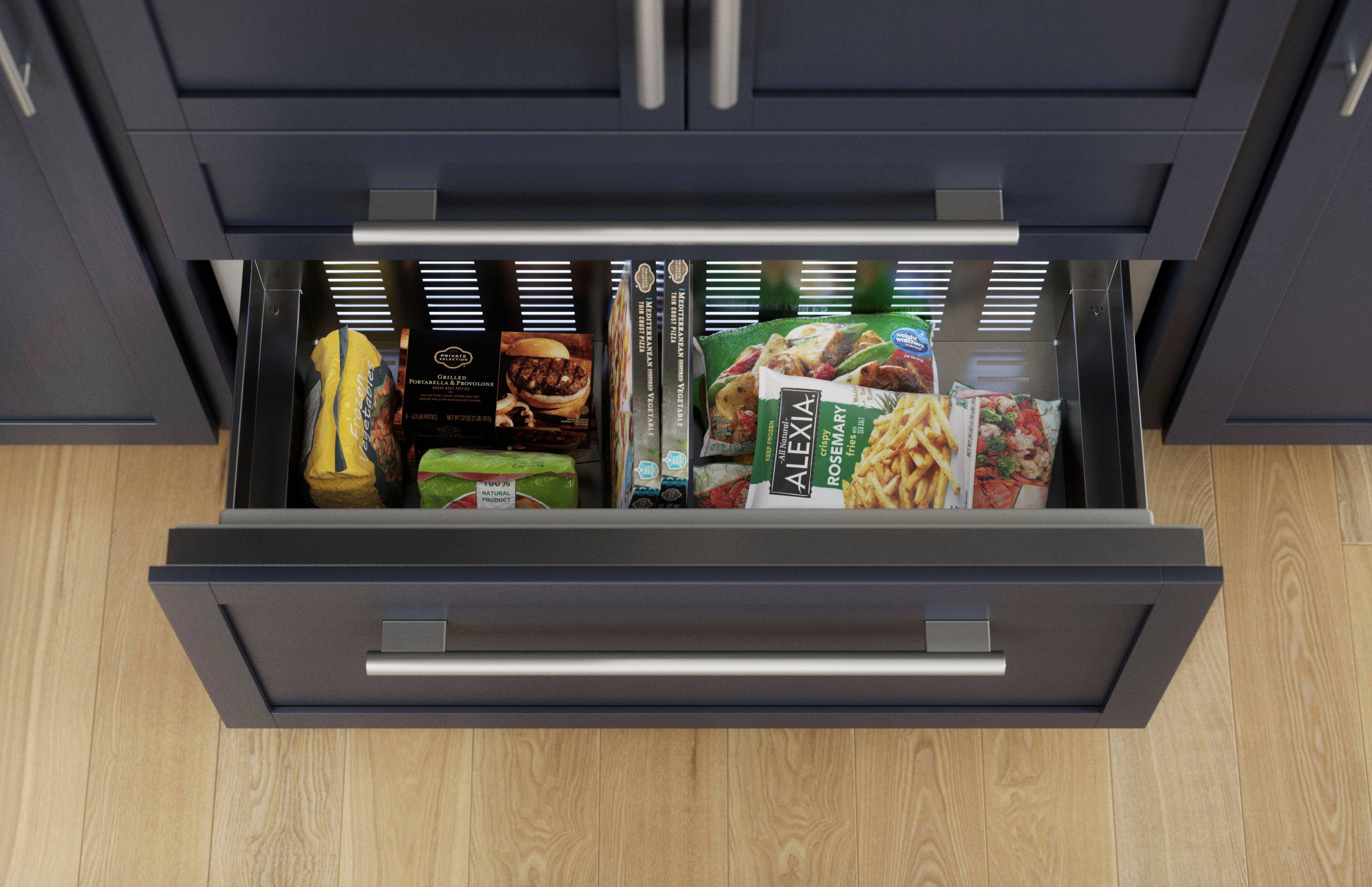 The image shows a kitchen cabinet with a drawer open, revealing various food items inside. The drawer is filled with frozen vegetables, including broccoli, and a box of fries. The items are neatly organized and easily accessible.