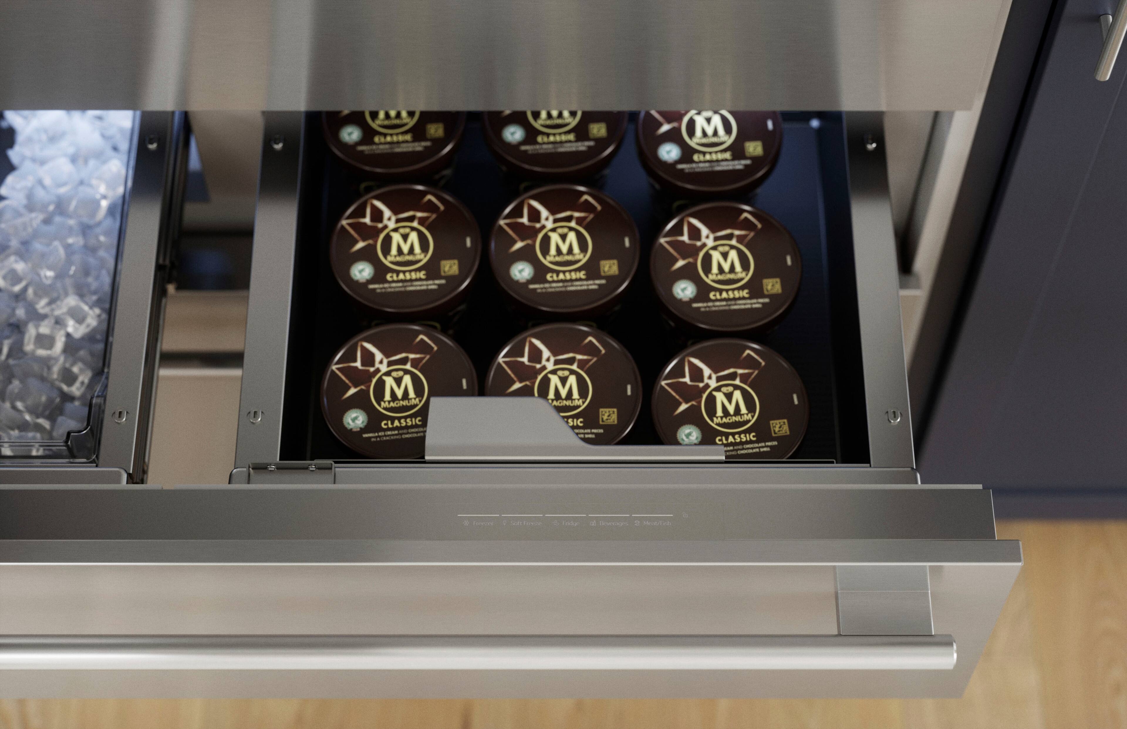 The image features a silver drawer with a dozen containers of Magnum ice cream. The containers are placed in a neat row, showcasing the various flavors of Magnum ice cream. The drawer is located in a kitchen, and the containers are easily accessible for serving or storing.