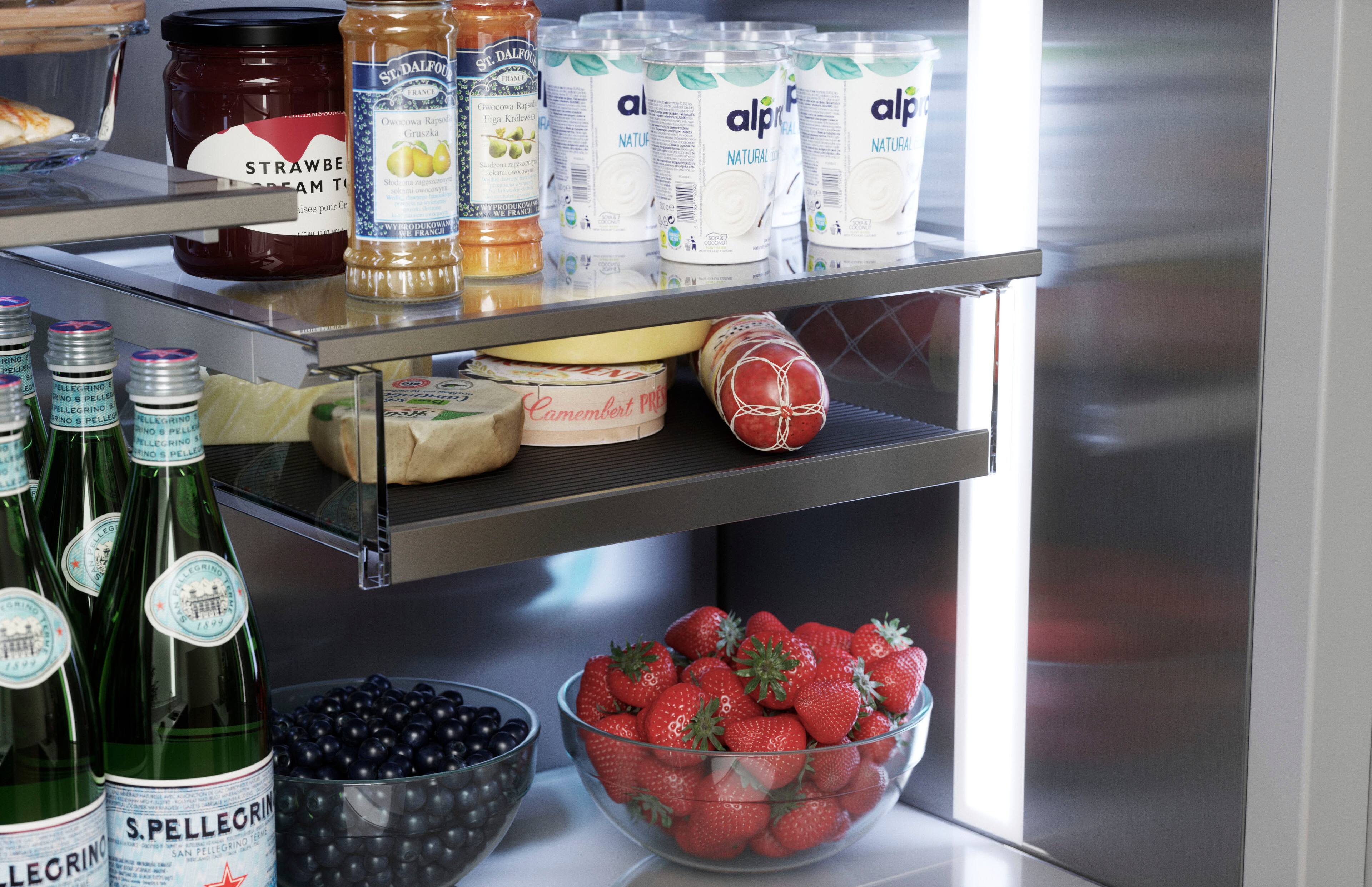 The image shows a refrigerator with a variety of food items and drinks inside. There are several bottles of water, some of which are placed on the top shelf, while others are on the middle and bottom shelves. Additionally, there are multiple bottles of wine, with some located on the top shelf and others on the middle shelf. 

In the refrigerator, there is also a bowl of fruit, which includes strawberries and blueberries. The strawberries are placed in a bowl on the middle shelf, while the blueberries are located on the bottom shelf. The refrigerator is well-stocked with a variety of food and drinks, making it a convenient and functional appliance for everyday use.