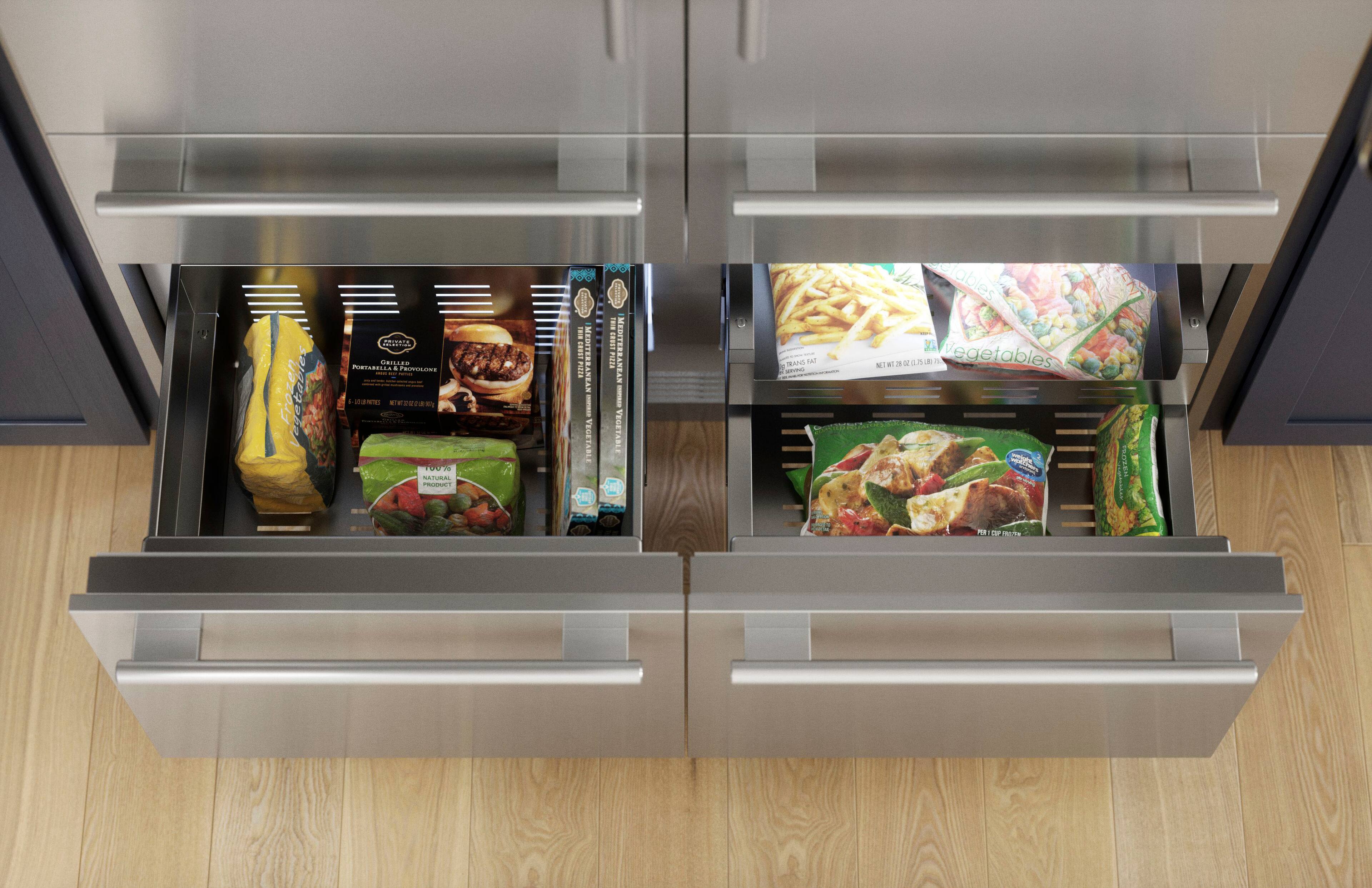 The image shows a refrigerator with two drawers open, revealing various food items. The text on the image reads "Frozen vegetables MU GRILAG PRTSBELLA - F I - I | | | . cht   - 10078 SATURAL RLD POO DOU I I I I I MEDITEREAN   SANTANTRALISAN m | RANEAN - I VEGETABLE VEGETABLE   TRANO L i a SA Ciables 1 N at 3 ot  . de Vegetables  N PeOnEn! P TP." This text appears to be a combination of different food items, such as frozen vegetables, natural vegetables, and other food items like pizza.