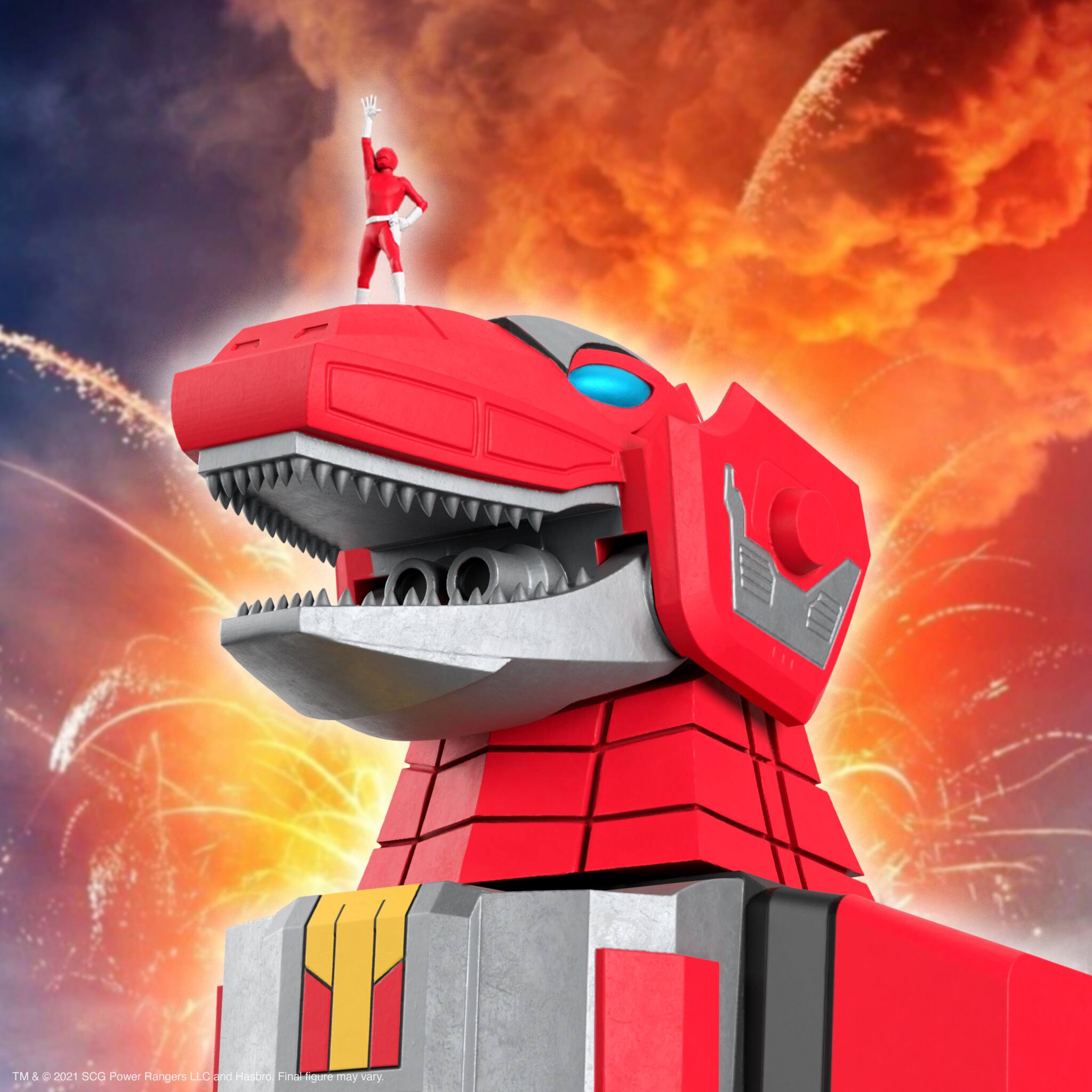The image features a red action figure of a robotic dinosaur, possibly a Godzilla toy, standing on top of a building. The toy is positioned in the center of the image, with its mouth open, and appears to be the main focus of the scene. The background is filled with fireworks, adding a sense of excitement and action to the scene.
