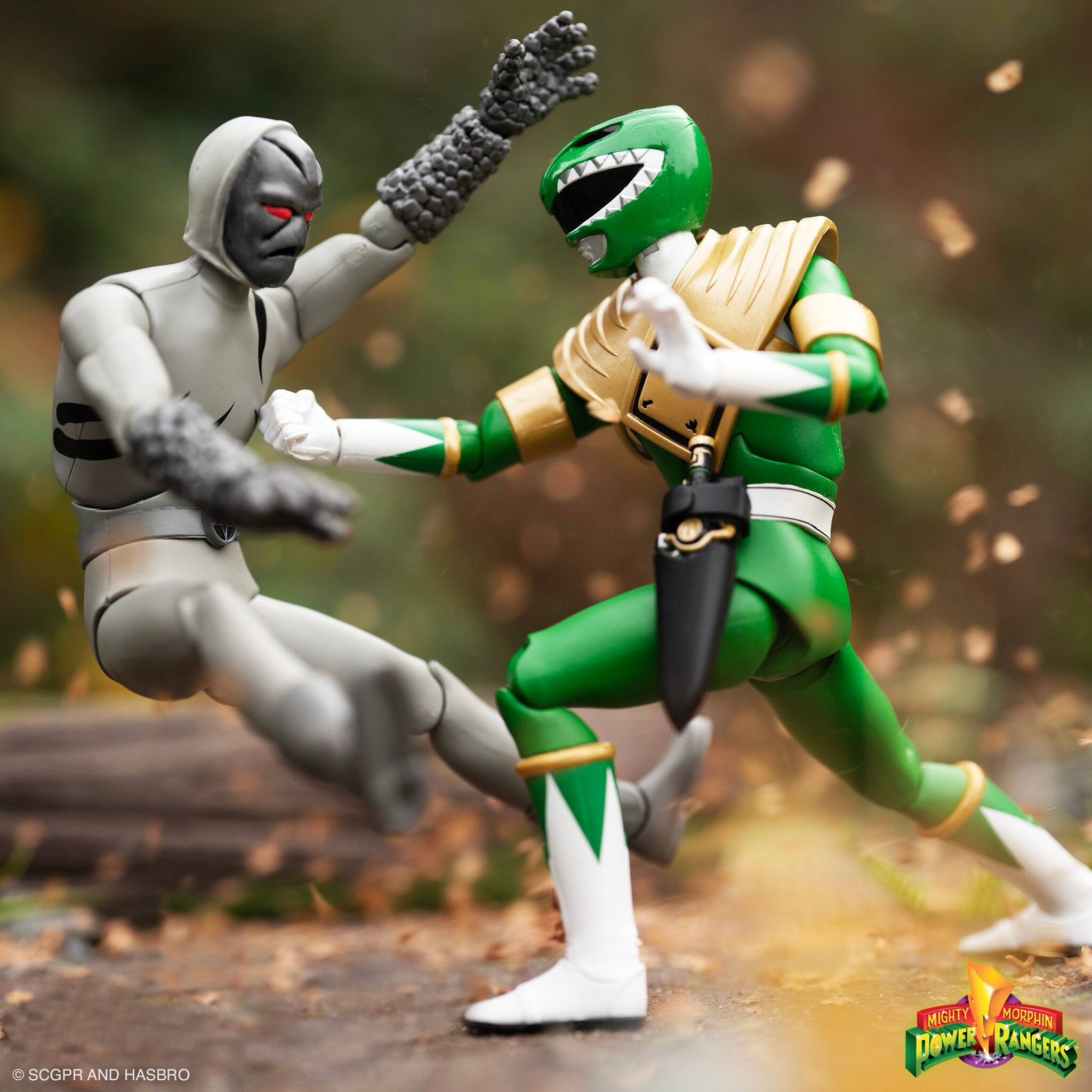 The image features two action figures from the Mighty Morphin Power Rangers series, both in their respective fighting poses. The figures are positioned in a dynamic scene, with one figure jumping over the other. The action figures are well-dressed, showcasing their unique costumes and accessories. The scene captures the essence of the Power Rangers' adventures and battles against evil forces.