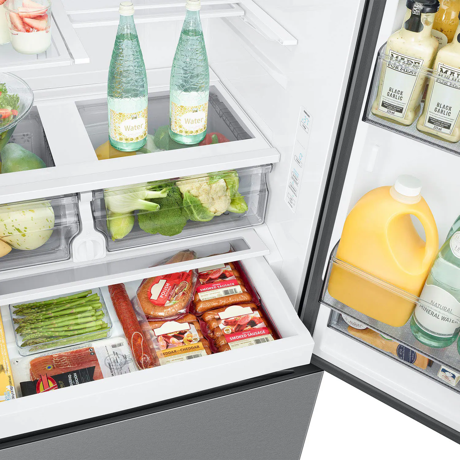 The image shows a refrigerator with various food items and drinks inside. The refrigerator is stocked with a variety of items, including water, juice, and other beverages. There are also several bottles of different sizes and shapes, some of which are placed on the top shelves and others on the bottom shelves. The refrigerator is filled with a mix of food and drinks, making it a well-stocked and functional appliance.