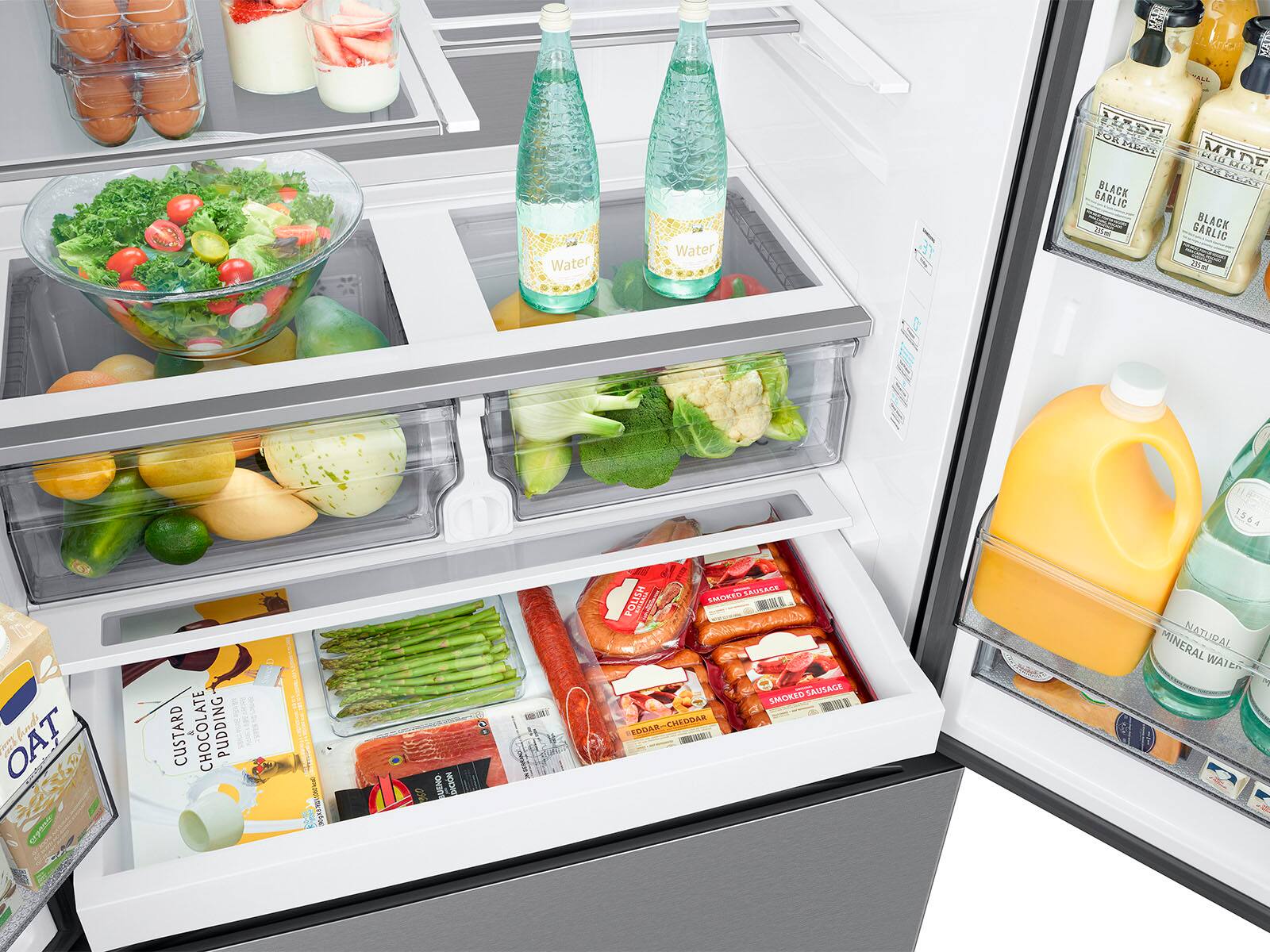 The text on the image is grouped and corrected as follows:

1. Beverages:
- Water: 2 bottles
- Juice: 1 bottle
- Milk: 1 bottle
- Coffee: 1 bottle
- Soda: 1 bottle
- Wine: 1 bottle
- Beer: 1 bottle
- Oat Milk: 1 bottle

2. Food items:
- Fresh vegetables: 2 bunches
- Fresh fruits: 1 bunch
- Meat: 1 package
- Dairy: 1 bottle
- Eggs: 1 dozen
- Bread: 1 loaf
- Pasta: 1 package
- Cereal: 1 box
- Snacks: 1 package
- Desserts: 1 cake
- Condiments: 1 jar

3. Refrigerator organization:
- The refrigerator is well-organized with various food items and beverages placed in their respective compartments.
- The vegetables are placed in the crisper drawers, while the fruits are stored in the fruit drawer.
- The meat, dairy, and eggs are stored in the main compartment, along with the bread and pasta.
- The cereal and snacks are placed in the pantry section, while the cake and desserts are stored in the freezer.
- The condiments are placed on the door shelves for easy access.

Overall, the refrigerator is well-stocked with a variety of food items and beverages, making it a convenient and functional space for storing and preparing meals.