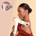 The image features a woman holding a hair dryer, which is part of the RapidGloss Finisher. This product is designed to help users achieve a naturally shiny finish by taking on frizz and flyaways. The woman in the image is wearing a red dress, and she is smiling while holding the hair dryer.
