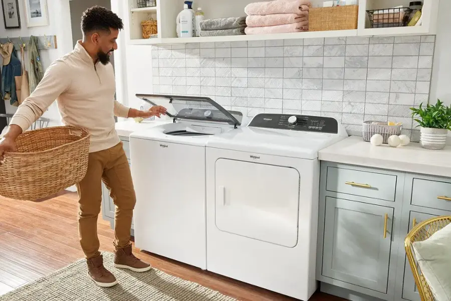 The image features a white Whirlpool washing machine with a black door. The machine is a front-loading washer, and it has a digital display on the front. The washer is designed to be energy-efficient and environmentally friendly, making it a popular choice for many households.