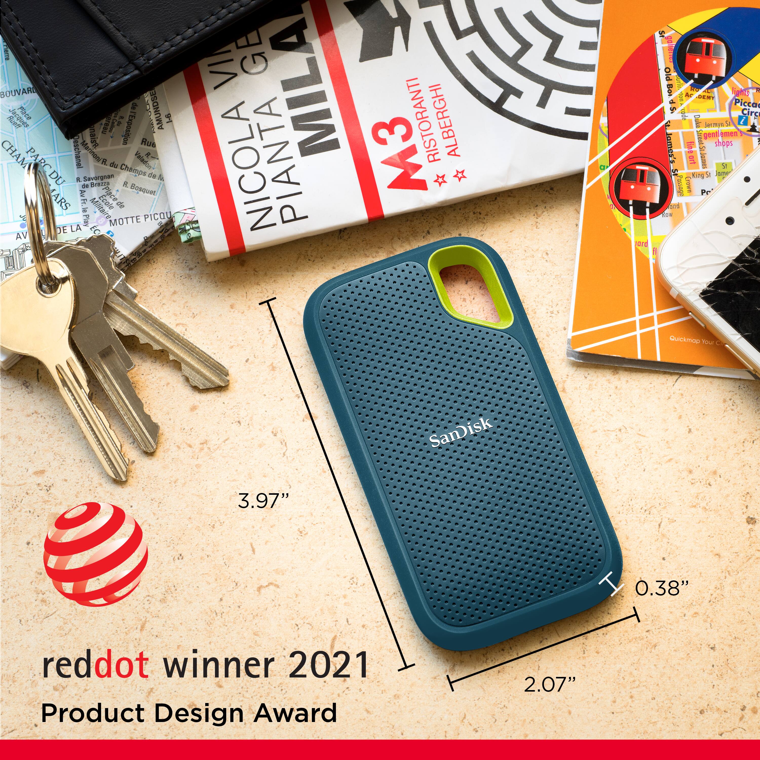 The image features a blue SanDisk cell phone case with a unique design. The case is placed on a table with several books and a wallet. The case is the main focus of the image, and it stands out due to its distinctive design. The reddot winner 2021 Product Design Award signifies that the case has been recognized for its innovative design and quality.