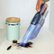 The image features a person holding a blue vacuum cleaner, which is advertised as having HyperVelocity suction power. The vacuum is designed with streamlined airflow for enhanced cleaning performance. The person is using the vacuum to clean a countertop, and the image showcases the vacuum's effectiveness in removing dirt and debris from the surface.