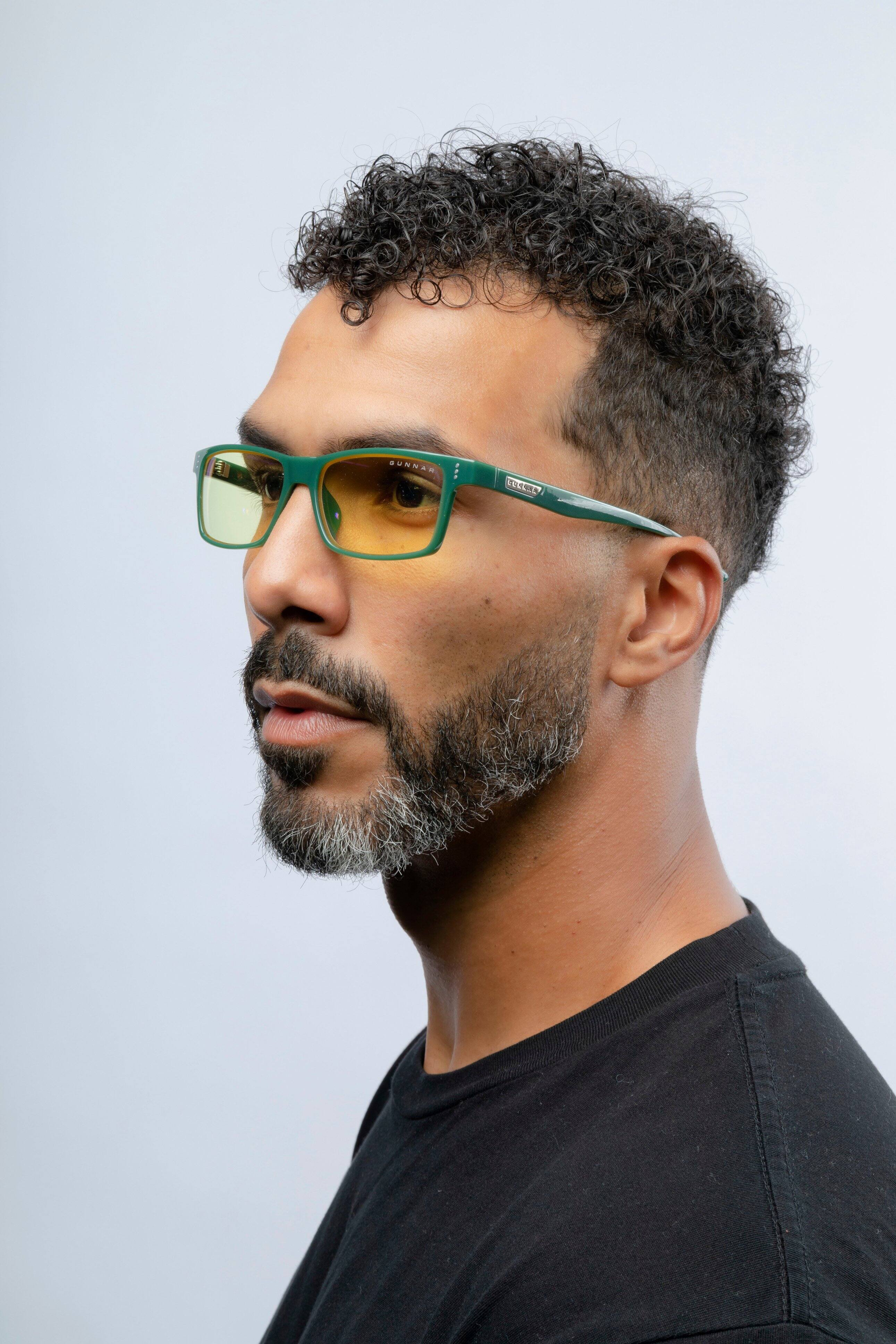 The man in the image is wearing a black shirt and glasses.