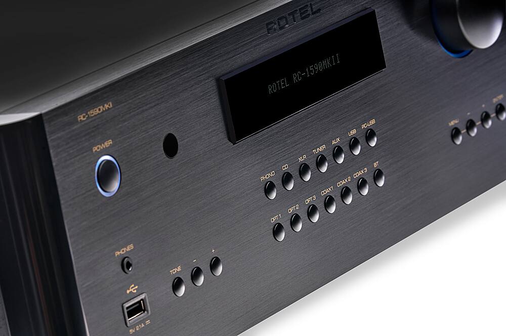 The text on the image reads: "RC-1580MKI FC- POWER ROTEL RC-1598NKII ROTEL PC-USB USB AUX TUNER XLR B BT PHONO COAX3 COAX2 COAX1 PT3 OPT2 OPT1 PHONES TONE 21A SV." This text describes the features of a device, possibly a stereo system, that includes a power source, a tuner, USB and AUX inputs, and various audio connections such as XLR, B, and PHONO. The device also has a COAX3, COAX2, and COAX1 input, as well as PT3, OPT2, and OPT1 options. The presence of a TONE setting suggests that the device may have adjustable sound settings.