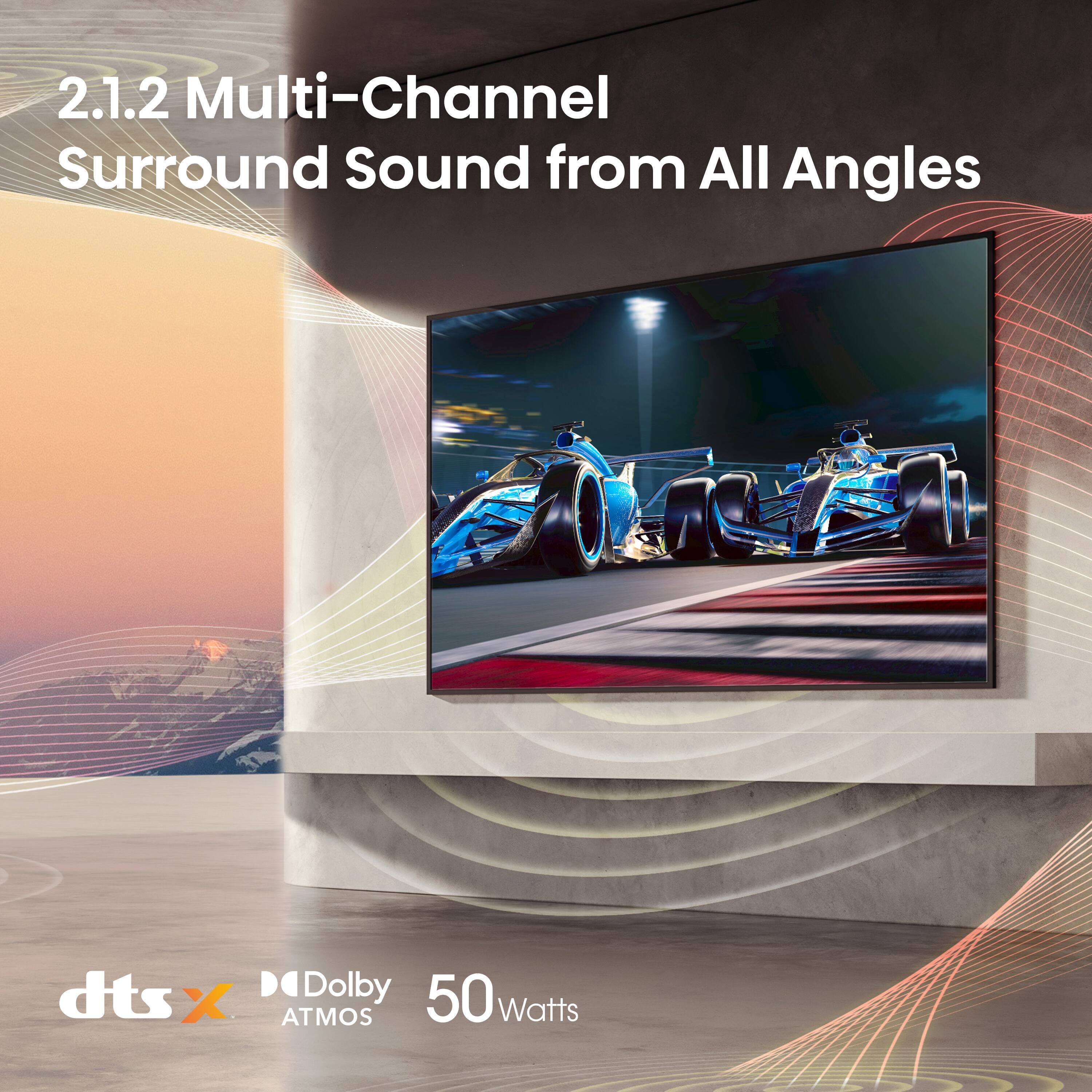 The image features a large flat screen TV mounted on a wall, showcasing a racing game. The TV is advertised as having 2.1.2 Multi-Channel Surround Sound from All Angles, which is powered by dts X and Dolby ATMOS technology. The TV is also rated at 50 watts, providing a high-quality audio experience for the viewer.