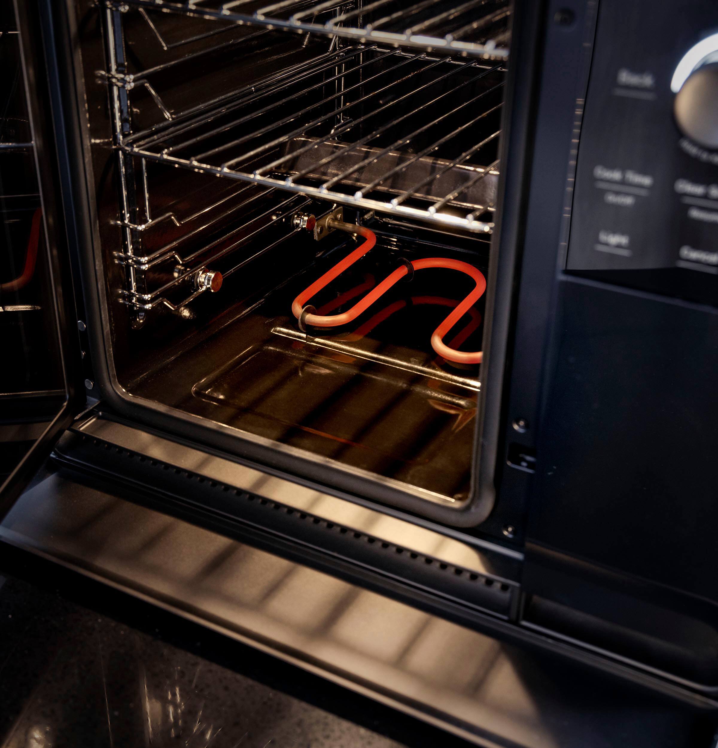 The image features a black oven with two pieces of meat inside, possibly pork ribs. The oven has a digital display and a timer, indicating that it is a modern appliance. The meat is being cooked in the oven, and the oven is likely being used for smoking or roasting the ribs. The oven is also described as a "smoker" and "probe" oven, suggesting that it has advanced features for cooking and monitoring the meat. The oven has been recognized as the "Best in Show" at the CES 2024 event, showcasing its innovative design and functionality.
