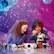 The image shows a boy and a girl sitting at a table, building a Lego space shuttle together. They are surrounded by various Lego pieces, including a truck and a car. The girl is on the left side of the table, while the boy is on the right. They are both focused on their project, enjoying their time together.