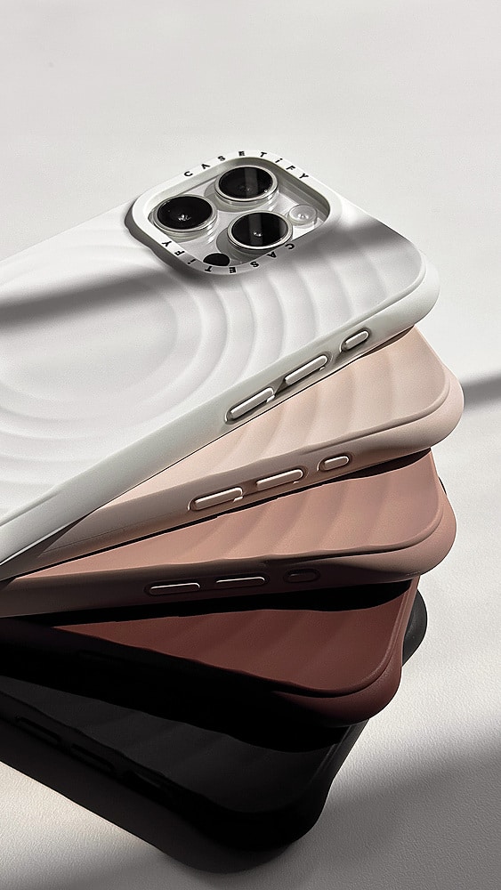 The image features a stack of four cell phones, each with a different color. The phones are placed on a white background, and their backs are visible, showcasing their unique designs. The colors of the phones are brown, pink, white, and black.