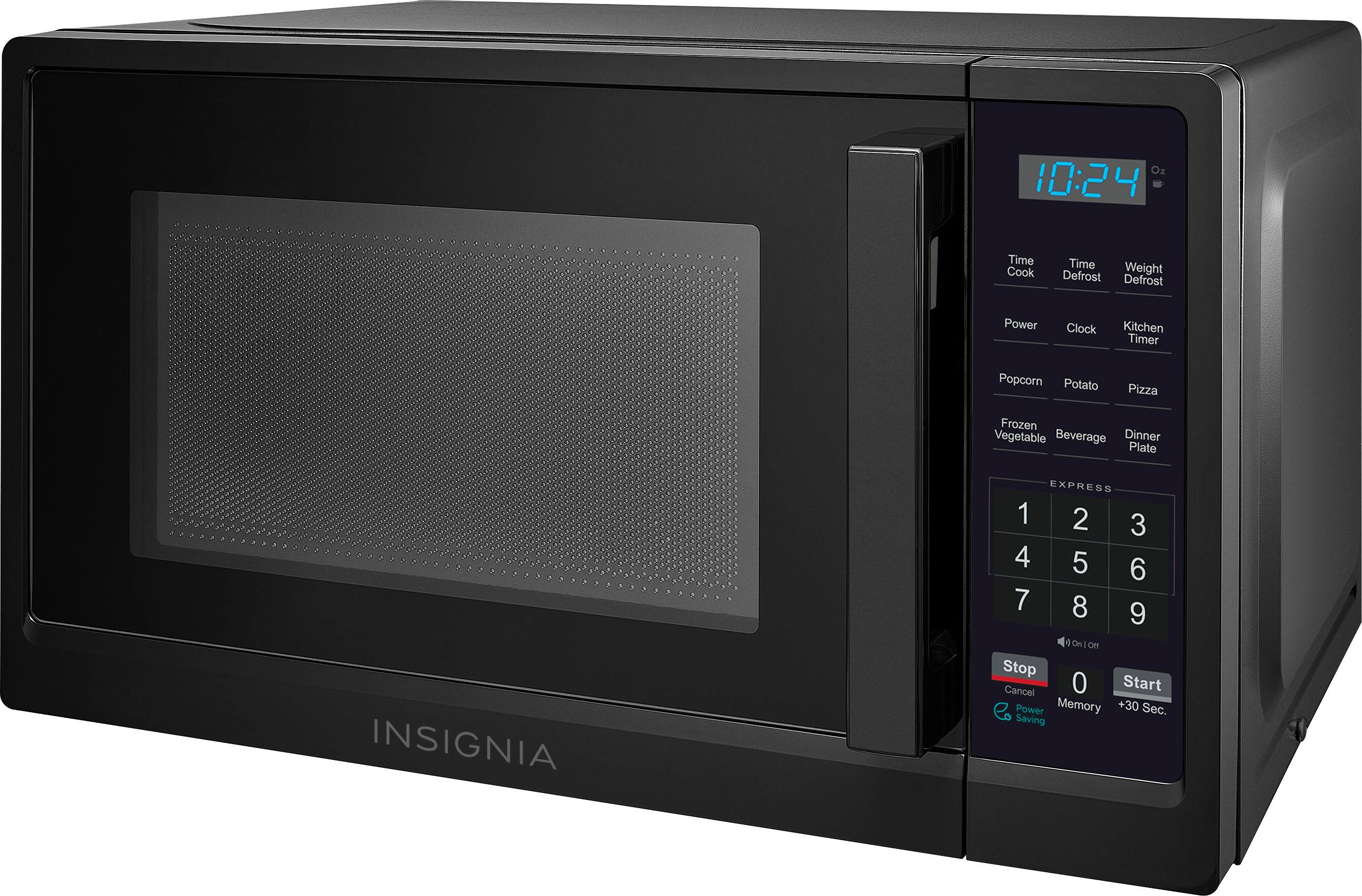 The image shows a black Insignia microwave with a digital clock on the front. The clock displays the time as 10:24. The microwave is a compact and efficient appliance, perfect for small kitchens or dorm rooms. It has various functions such as defrost, cook, and timer, making it a versatile addition to any kitchen. The microwave also has a popcorn, potato, pizza, frozen vegetable, and beverage settings, as well as a dinner plate setting. The digital display and buttons make it easy to use and navigate through the different functions.